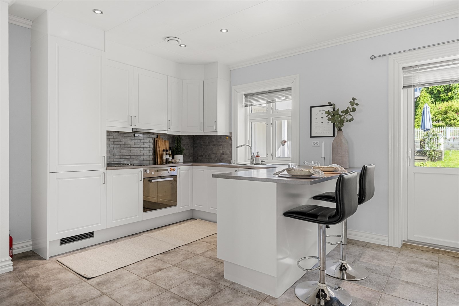 Tidløs innredning med hvite profilerte fronter og laminert benkeplate Galleribilde