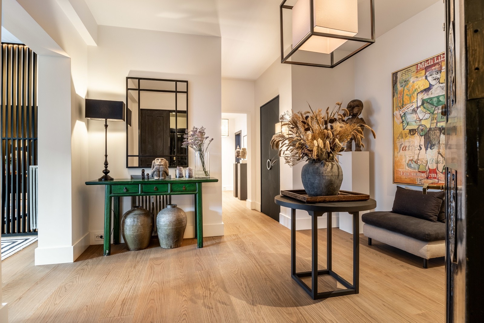 Stort og romslig inngangsparti med lekker enstavs eikeparkett på gulv, lyse vegger, peisovn og innebygde garderobeskap. Galleribilde