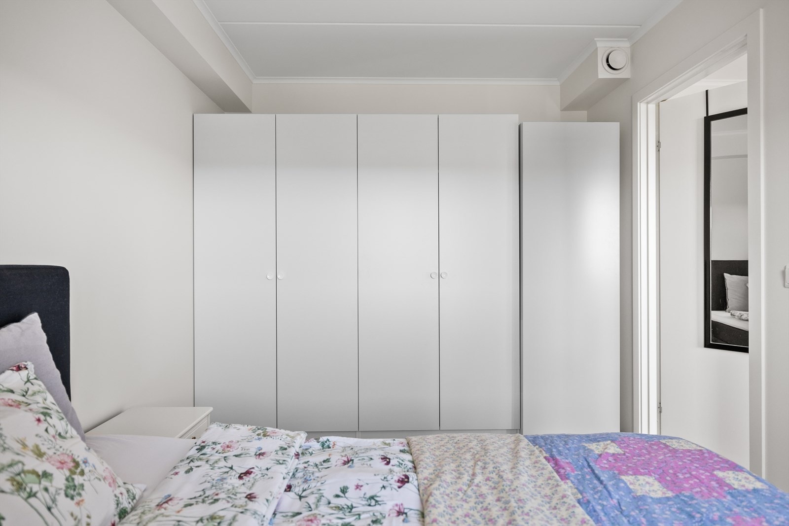 Soverommet er romslig med god plass til både dobbeltseng, nattbord og ekstra oppbevaring. Det er montert praktiske garderobeskap som gir gode oppbevaringsmuligheter og bidrar til et ryddig og funksjonelt rom. Galleribilde