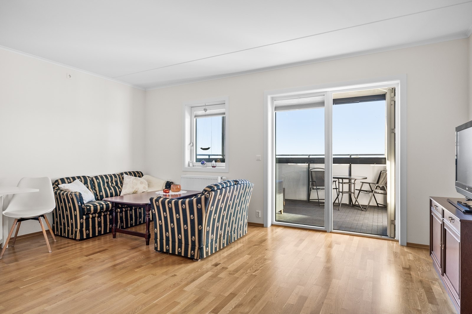 Stuen er et lyst og innbydende samlingspunkt som virkelig badet i naturlig lys fra de store vindusflatene. Her strømmer solen inn og skaper en luftig og behagelig atmosfære som løfter hele rommet. Galleribilde