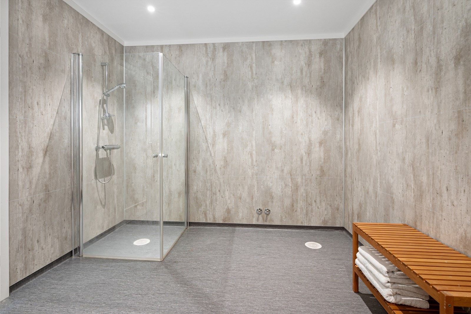 Utstyrt med innfellbare dusjdører, servantskap, veggmontert wc og mekanisk avtrekk. Galleribilde