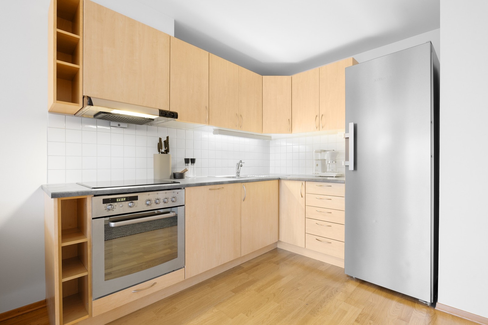 Kjøkkenet er innredet med glatte fronter og benkeplate er av laminat. Kjøkkenet har stekeovn, platetopp og stekeovn. Galleribilde