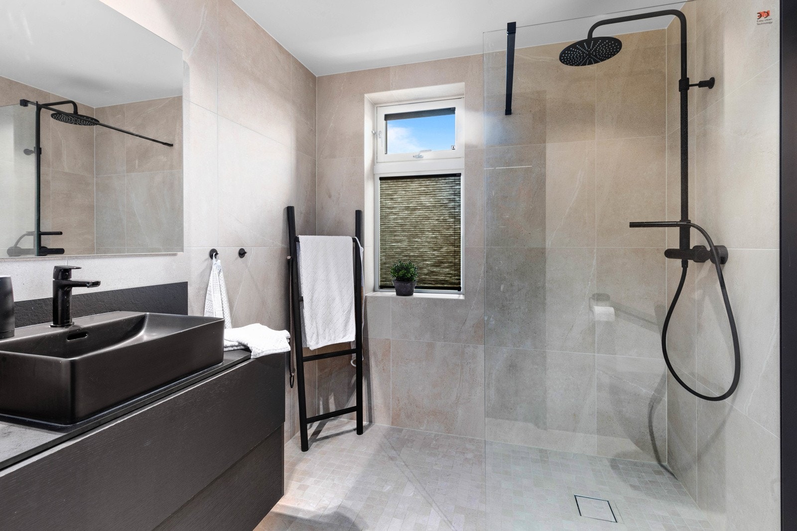 Badet er elegant og stilrent med fliser på både gulv og vegger Galleribilde