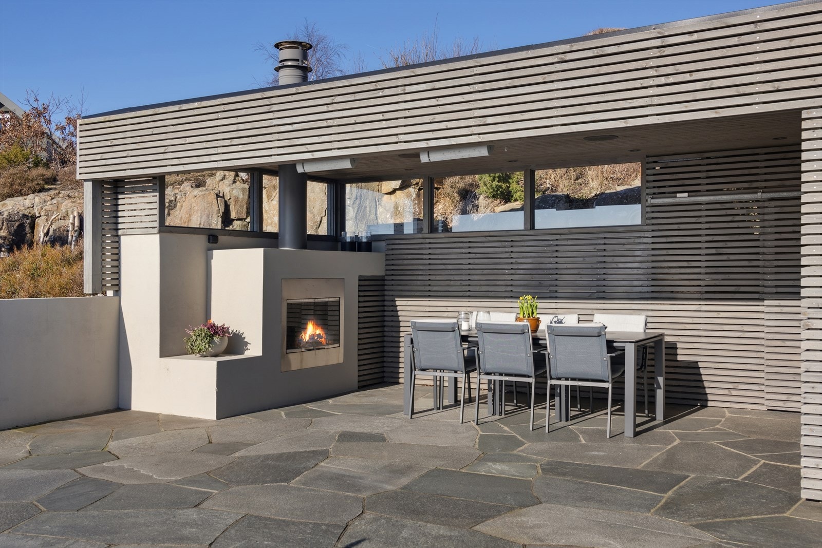 Delikat plassbygd peis gir både stemning og varme i hagestuen Galleribilde