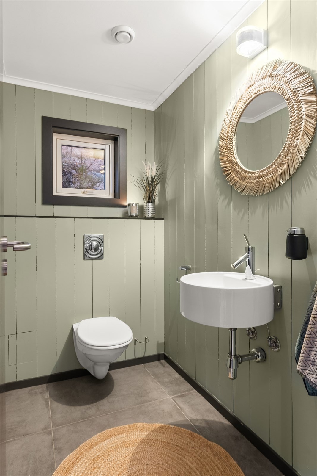 Toalettrom har vegghengt toalett og servant. Galleribilde