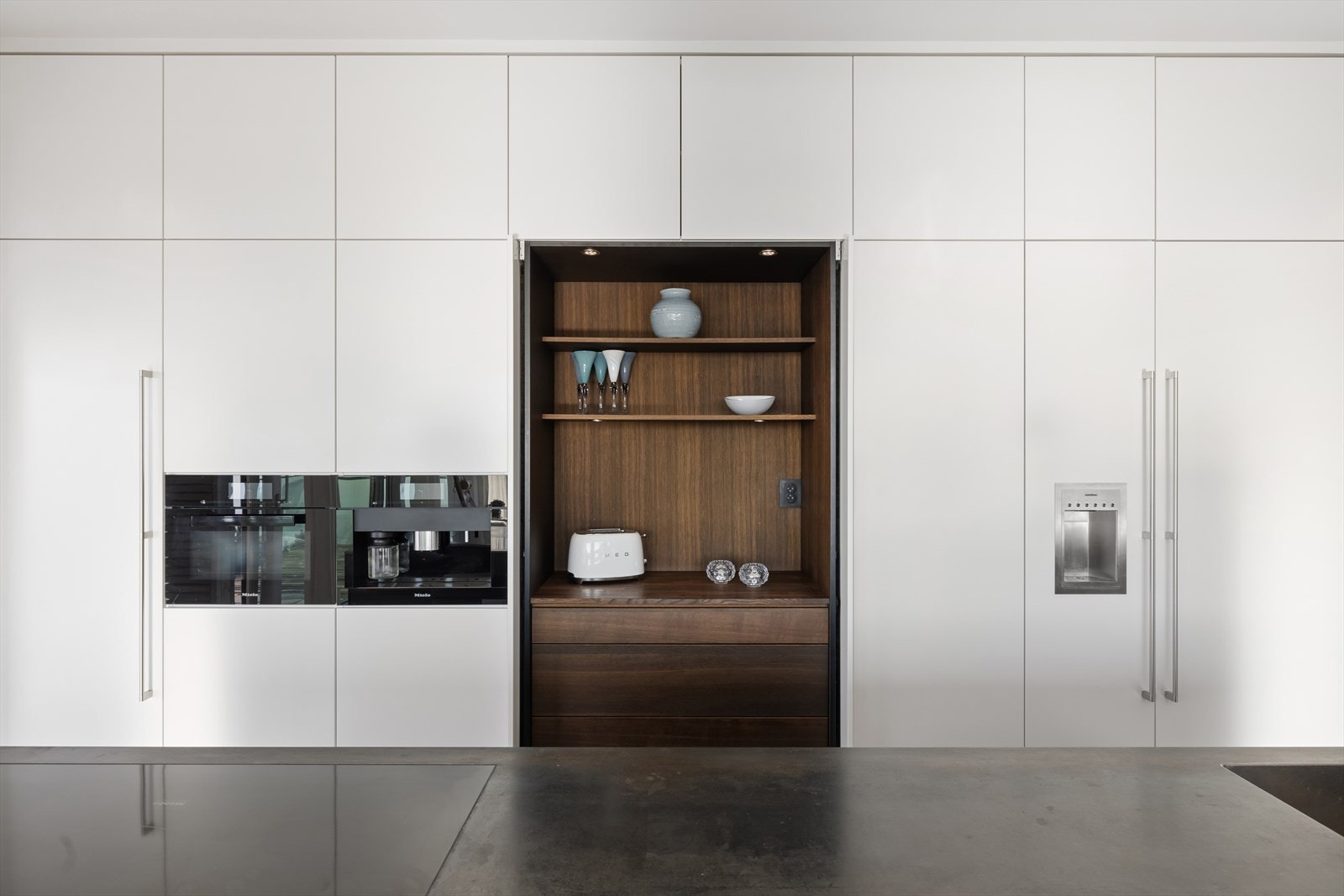 Integrerte hvitevarer fra Gaggenau/Miele som koketopp, 2 stekeovner hvorav en med dampfunksjon, kaffemaskin, oppvaskmaskin, vinskap, kjøleskap og fryseskap. Galleribilde