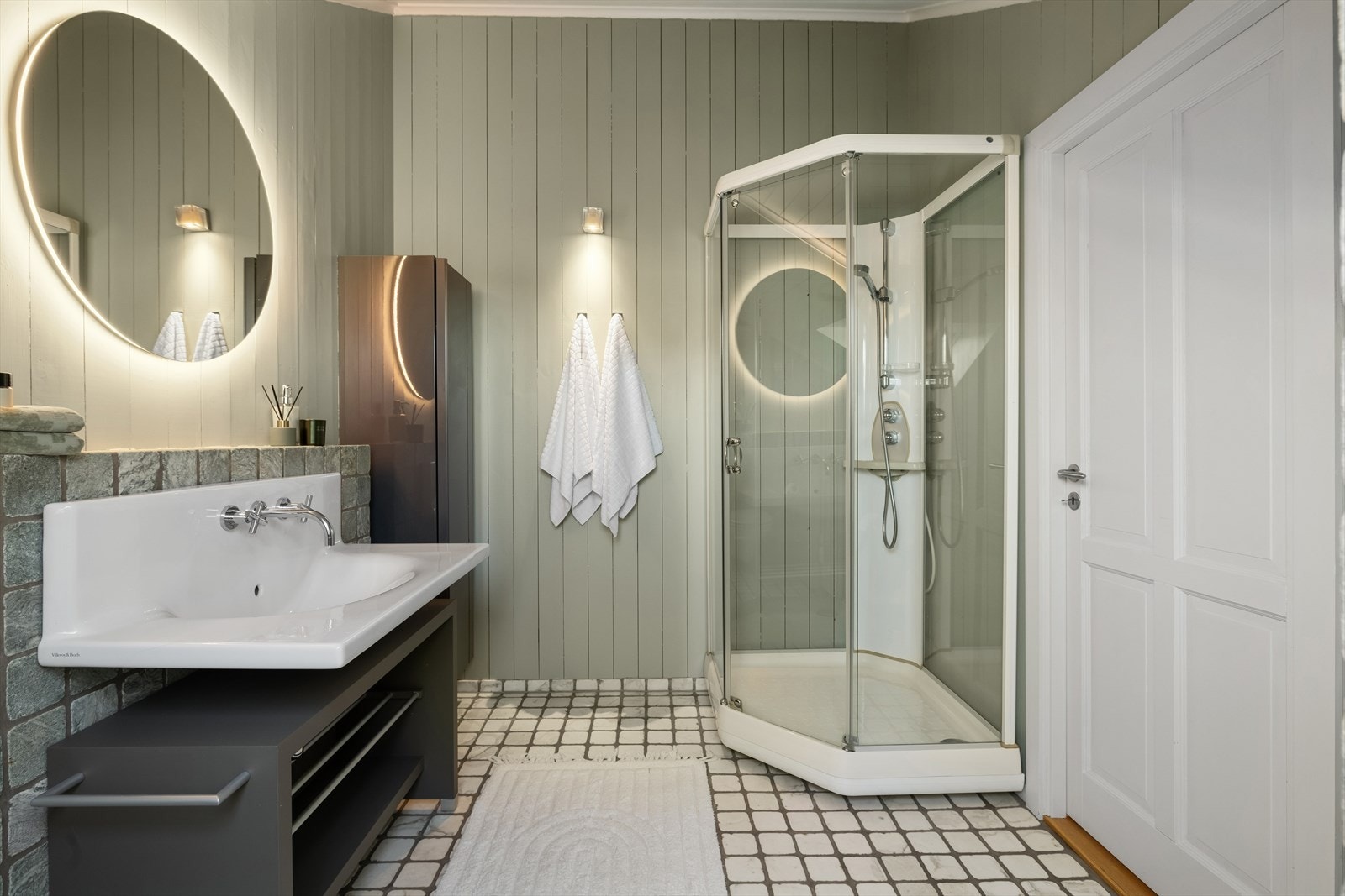 Rommet er utstyrt med veggmontert toalett, dusjkabinett, servant, innredning og speil. Galleribilde