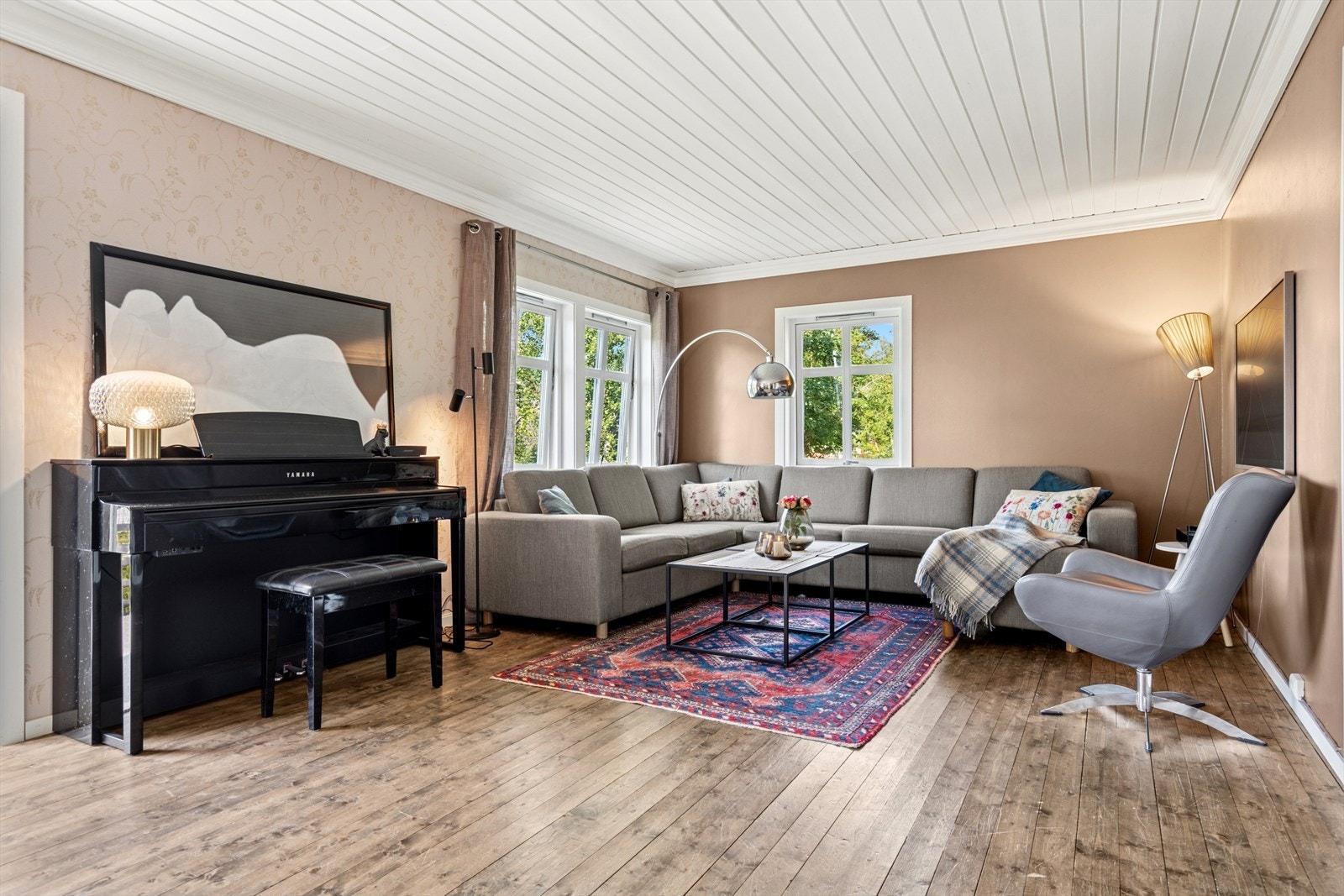 Stuen har malte vegger i en dus beige farge, komplimentert med en hvit himling som passer perfekt til boligens stil. Galleribilde