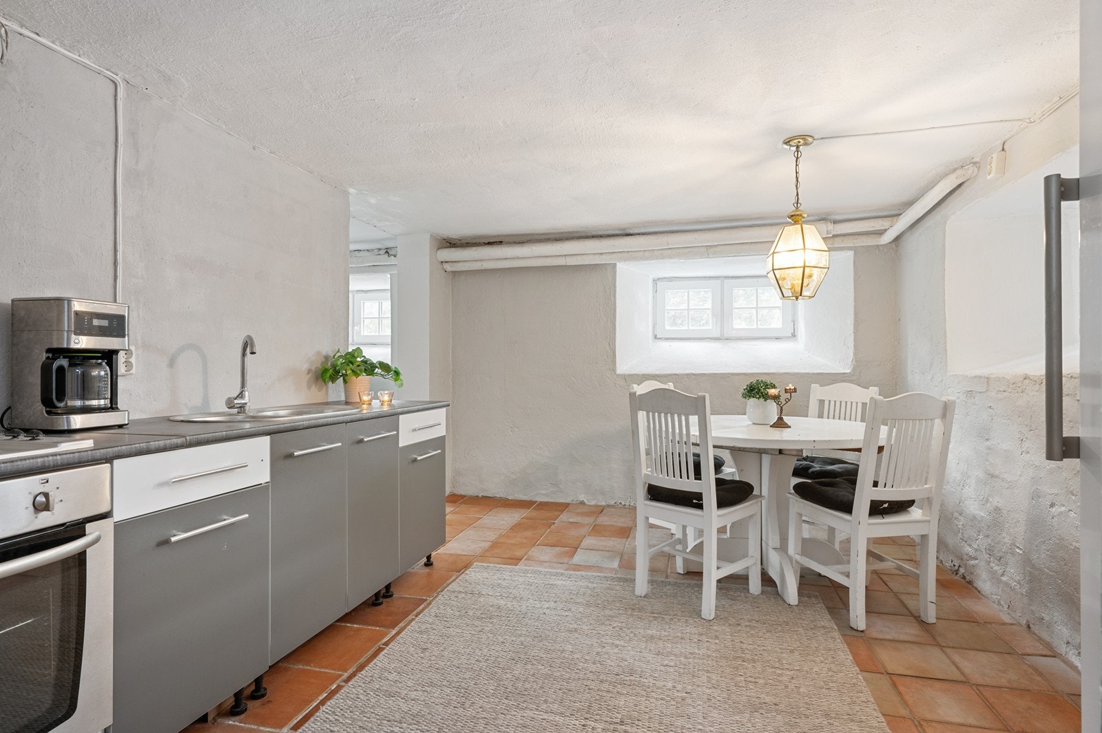 Enkel kjøkkeninnredning i kjelleren med integrert stekeovn og platetopp Galleribilde