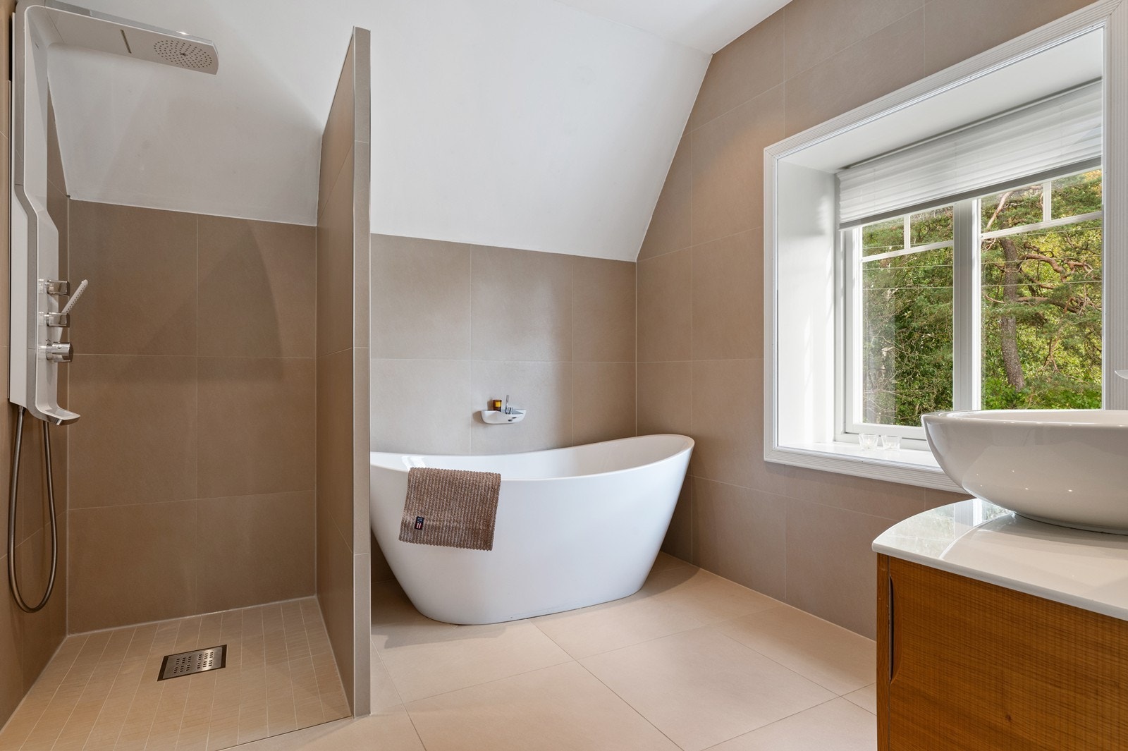 Fresht flislagt bad i 2. etasje med varme i gulv og innredning med dusjnisje, badekar og servantinnredning. Godt med dagslys fra vindu! Galleribilde