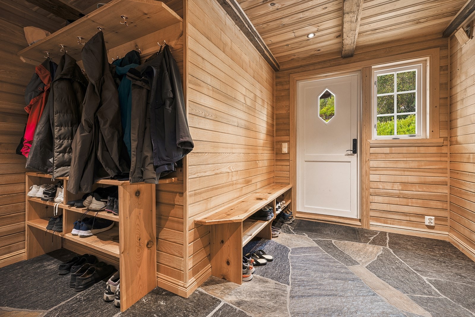 Det første man kommer til i boligen er en romslig entre med god plass til sko og ytterbekledning. Her er det også nydelig skifergulv med varme i. Galleribilde