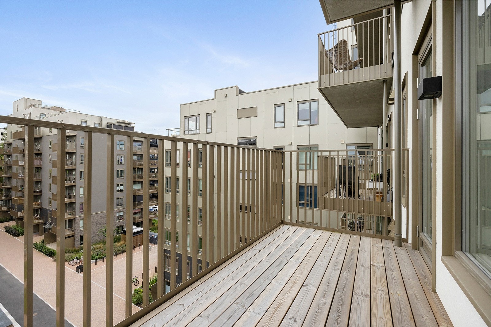 Balkongen vender ut mot planlagt frodig og moderne gårdsrom. Galleribilde