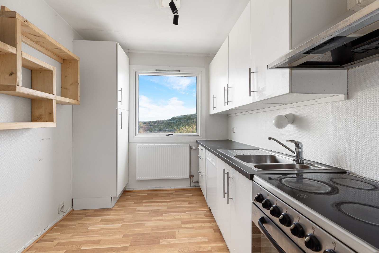 Kjøkkenet har hvite glatte fronter. Laminert benkeplate, med nedfelt oppvaskkum. Galleribilde