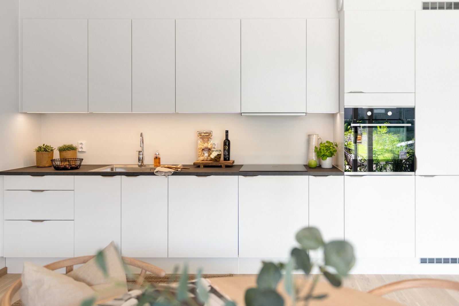 Stilrent kjøkken fra HTH med integrerte hvitevarer, ovn i høyskap Galleribilde