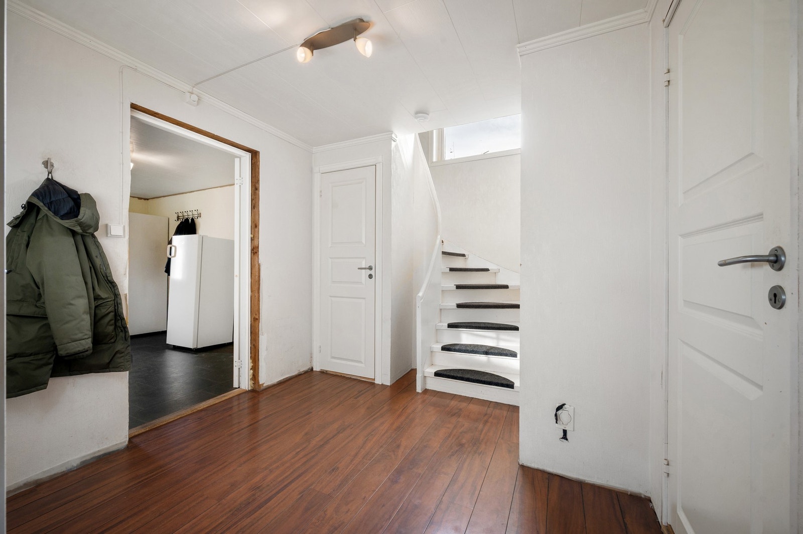 Hall med trapp til 2. etasje og dør med trapp ned til kjeller Galleribilde