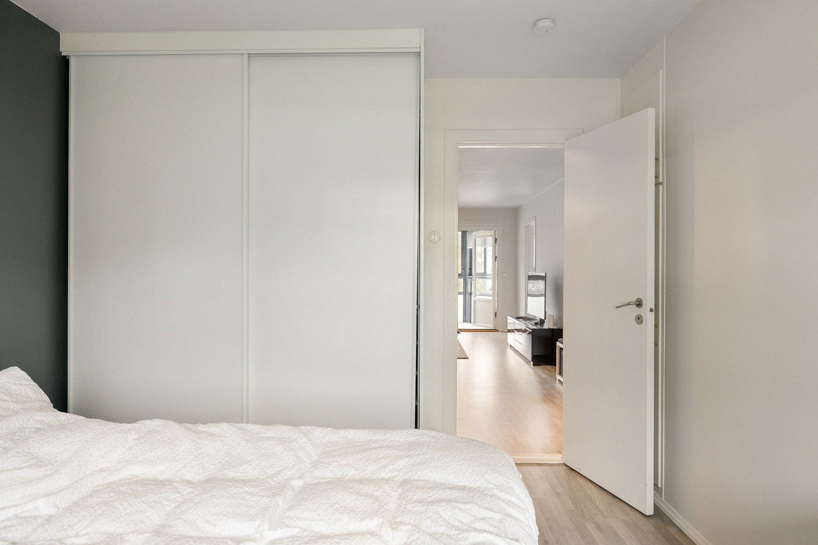 Hovedsoverommets skyvedørsgarderobe oppbevarer klærne lett tilgjengelig ved sengens side. Galleribilde