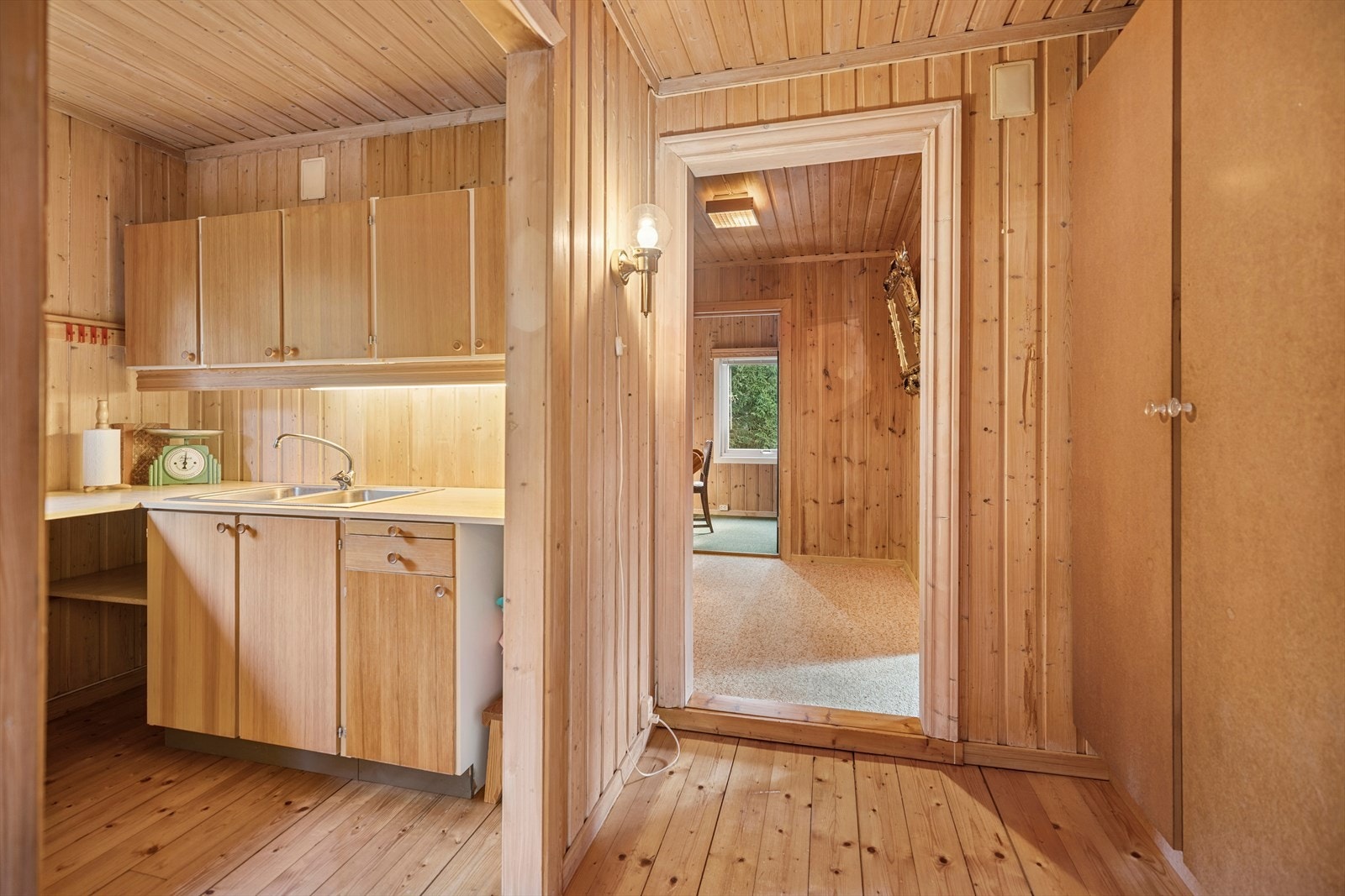 Eldre kjøkkeninnredning med slette fronter og foliert benkeplate med oppvaskkum. Galleribilde