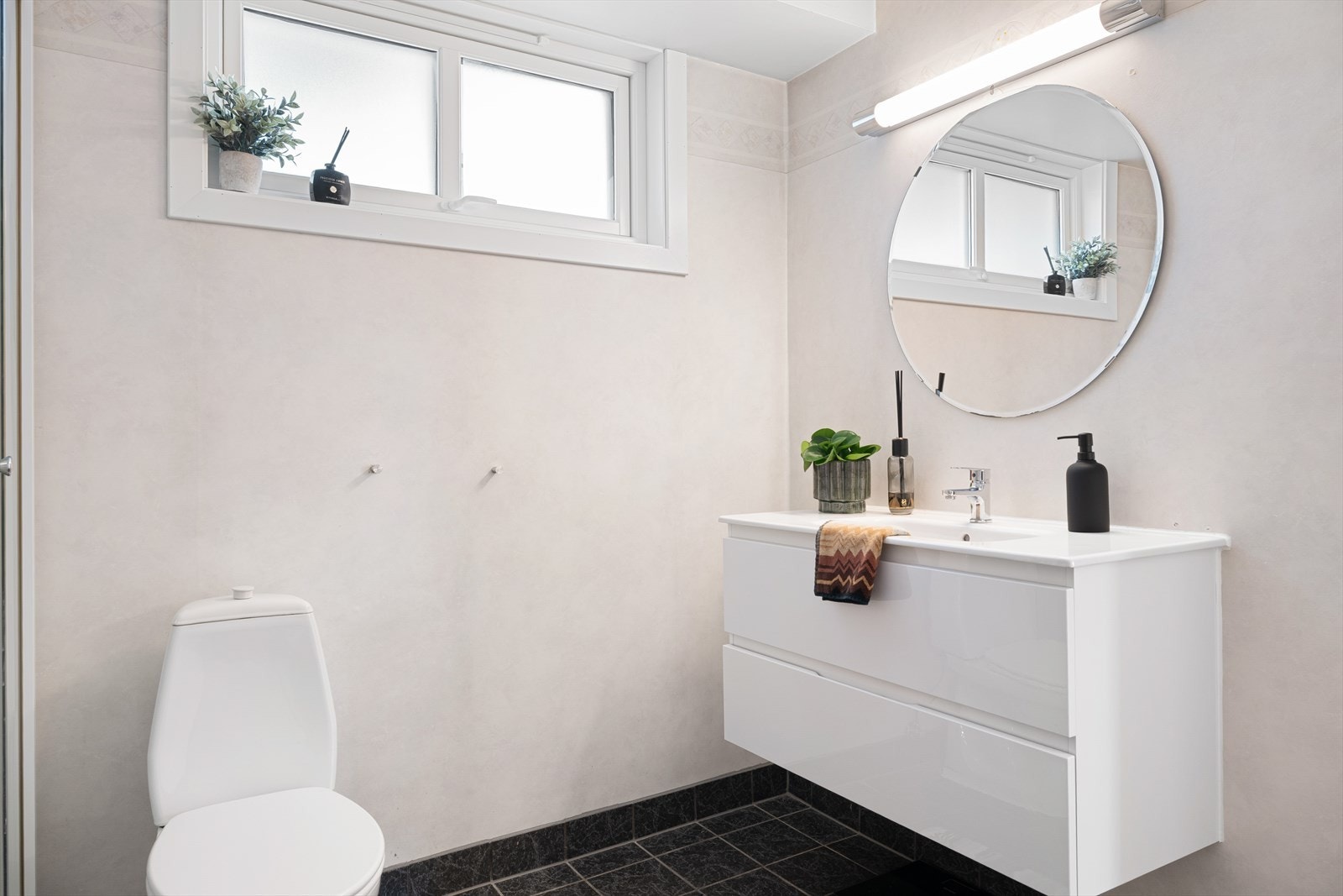 Badet er praktisk utformet med vegghengt servant, toalett, dusjkabinett og opplegg for vaskemaskin. Galleribilde