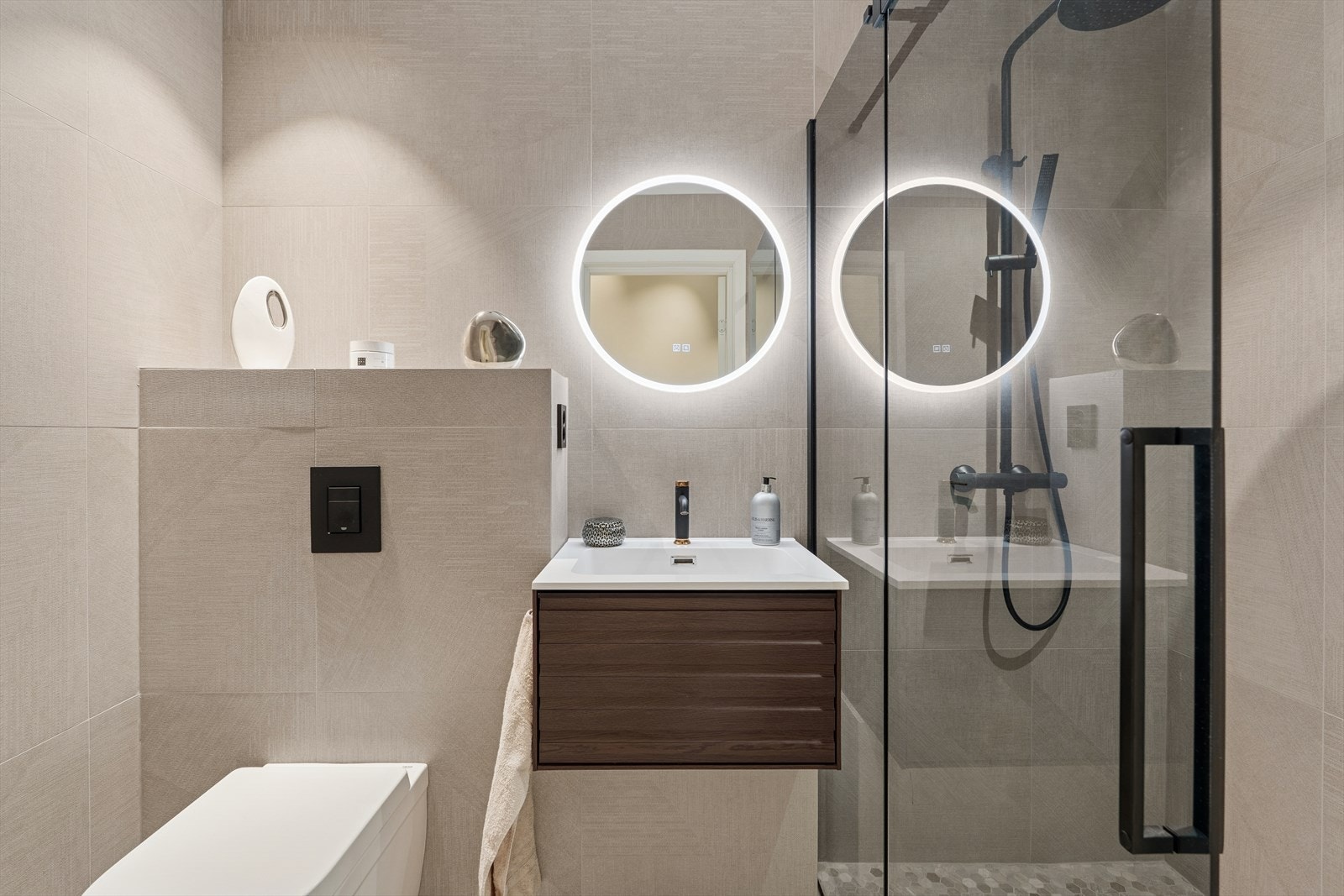 Bad 2 med dusjnisje og dusjdører, baderomsinnredning og vegghengt toalett Galleribilde