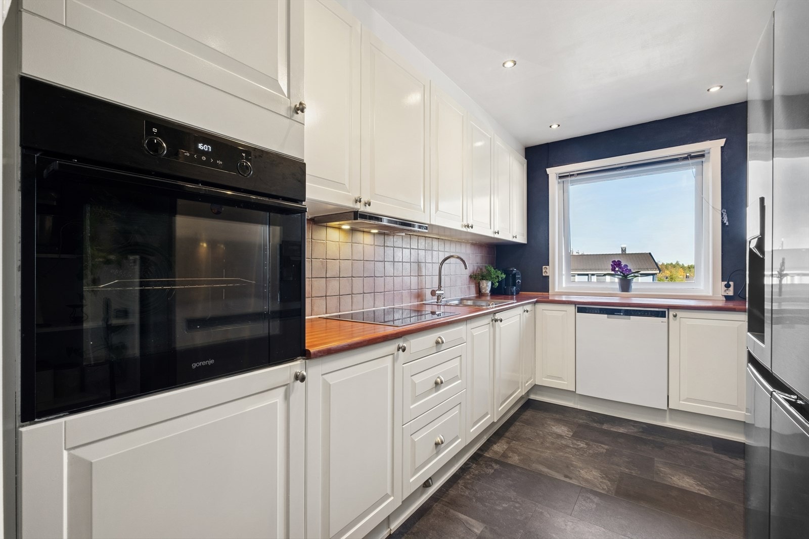 Kjøkkenet fremstår pent og med lyse profilerte fronter Galleribilde