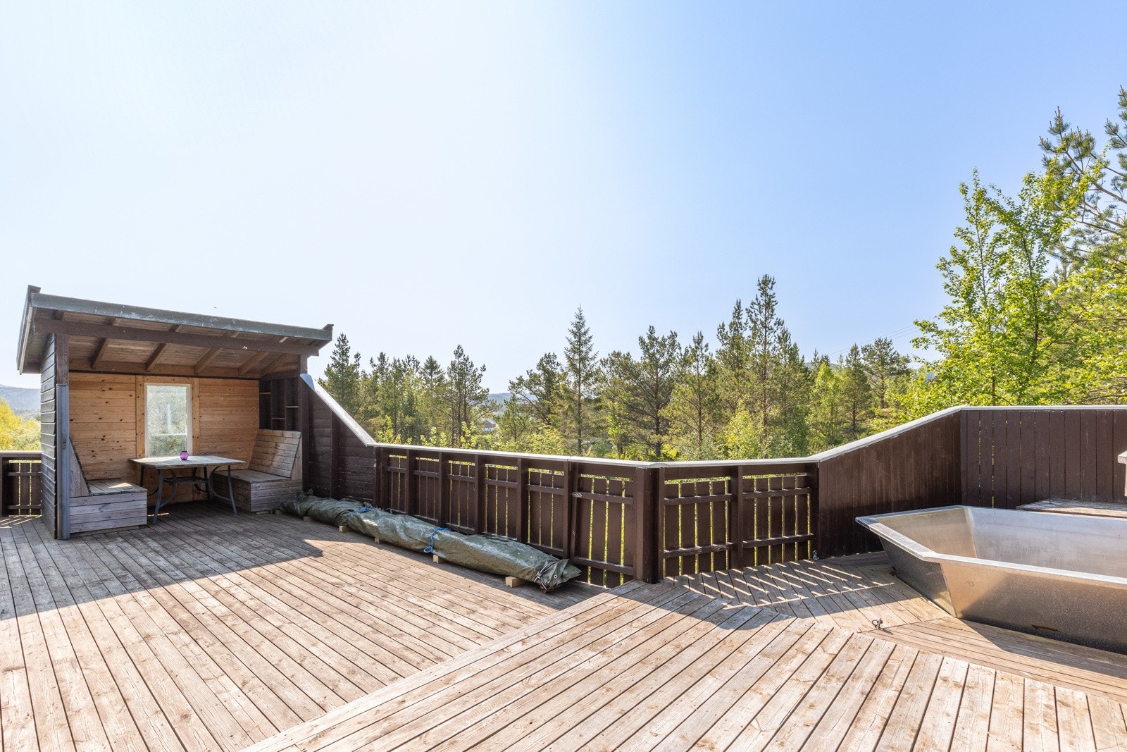 Eiendommen har en ellers skjermet og usjenert beliggenhet, med store terrasser som strekker seg nesten rundt hele hytten. Galleribilde