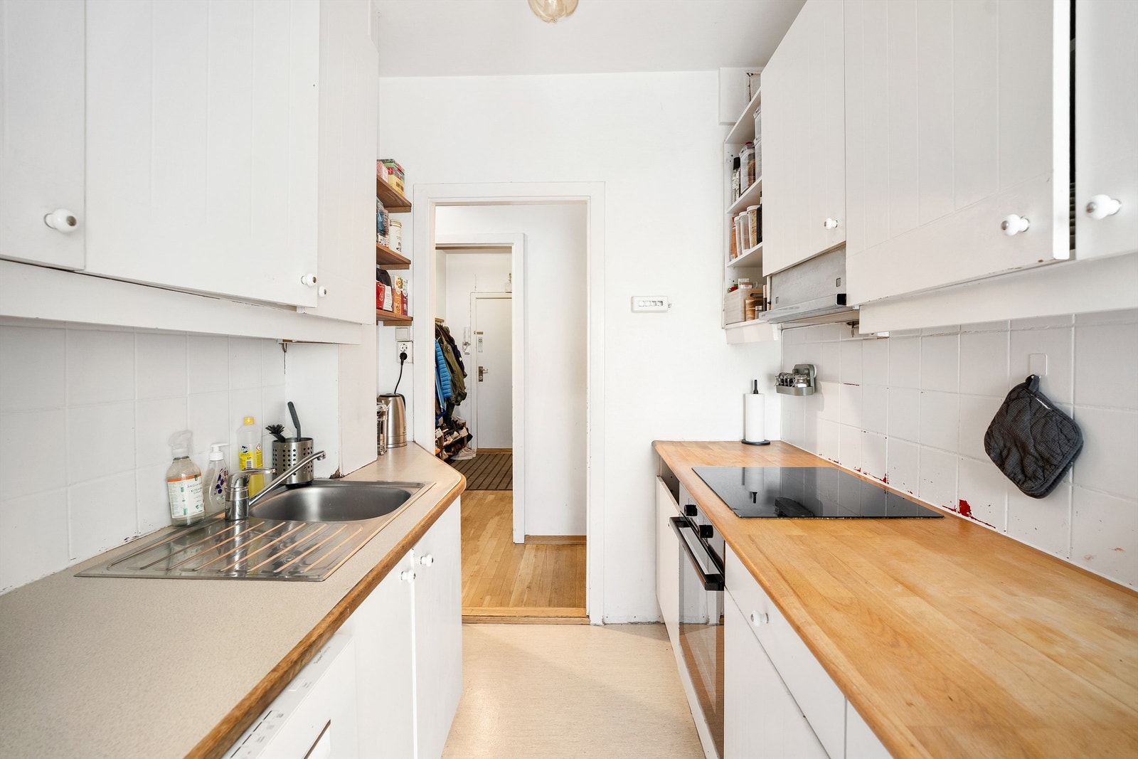 Det er flislagt mellom kjøkkenbenk og overskap som fører til stilig utrykk og enkel rengjøring. Galleribilde