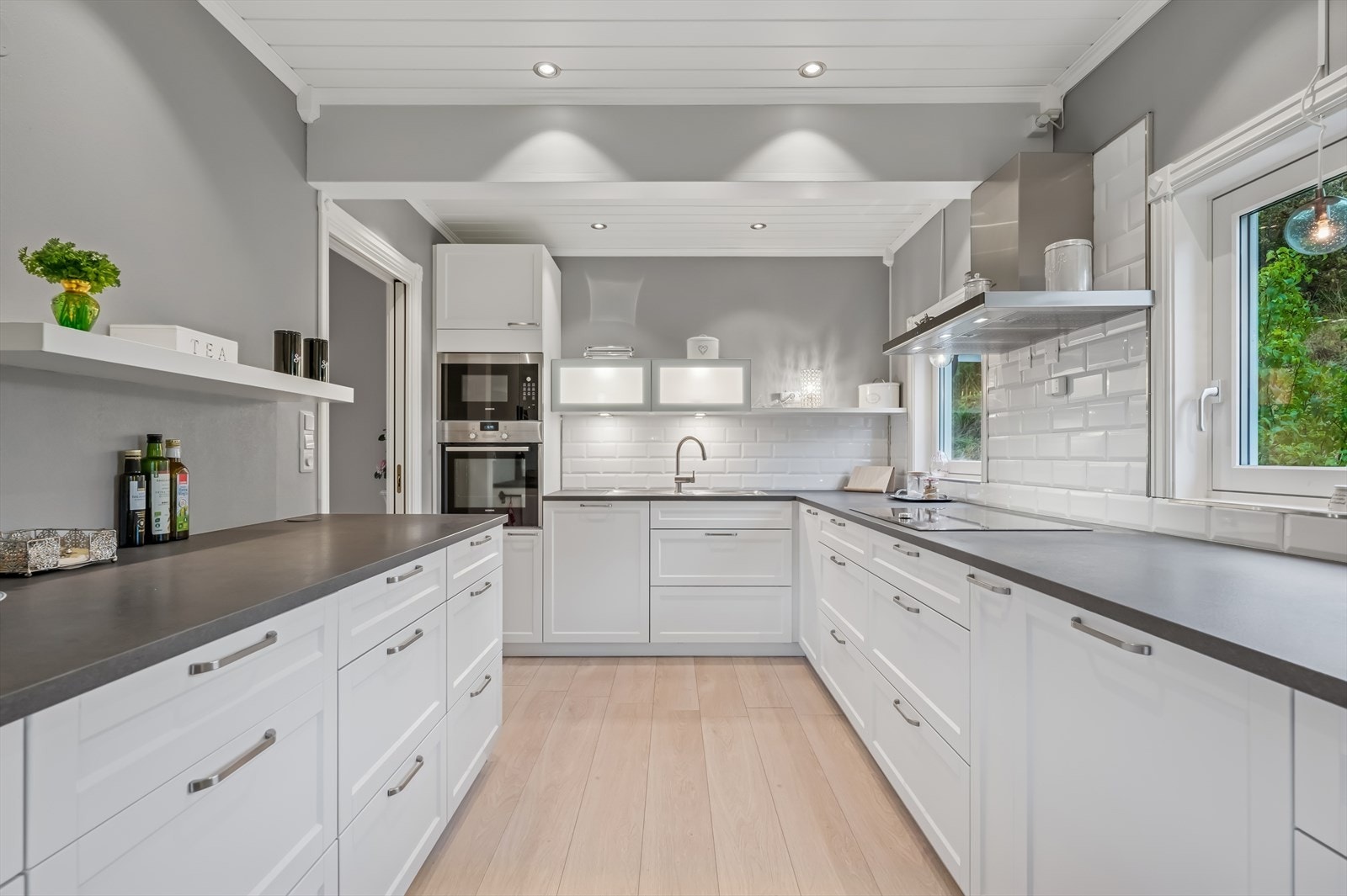 Kjøkkeninnredning med behandlet overflater, laminat benkeplater og stål oppvaskkum / beslag. Galleribilde