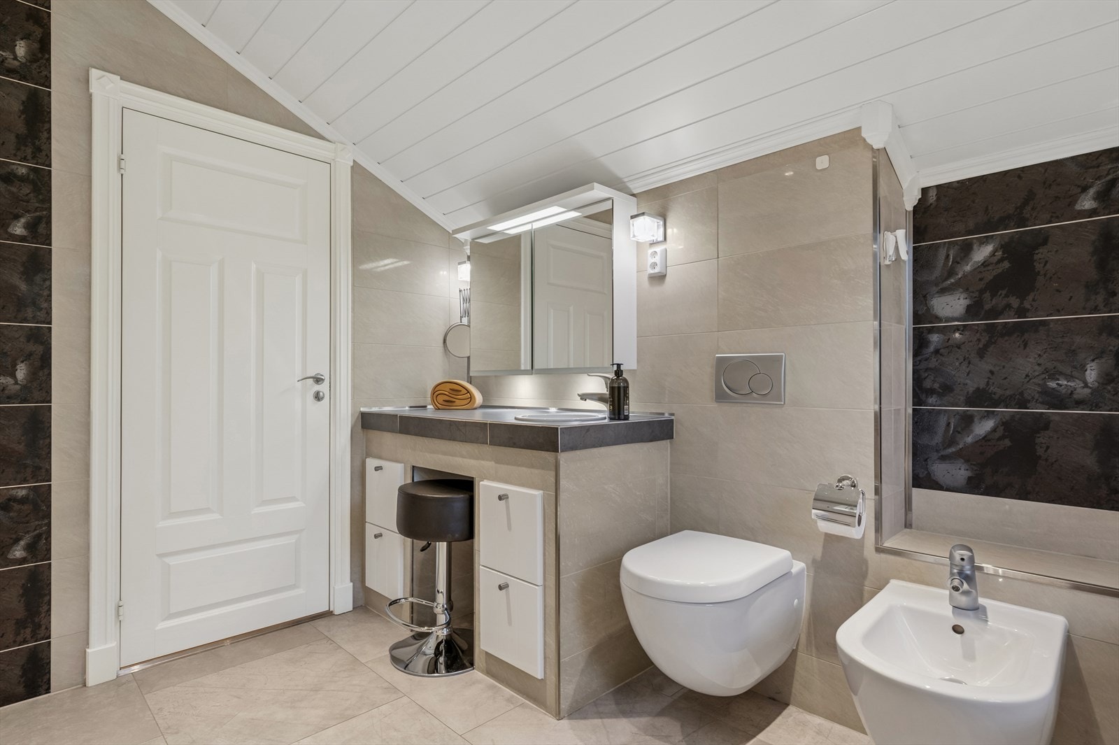 Baderomsinnredning med heldekkende servant, overskap med speil, vegghengt toalett, bide, innebygget badekar og dusjkabinett. Galleribilde