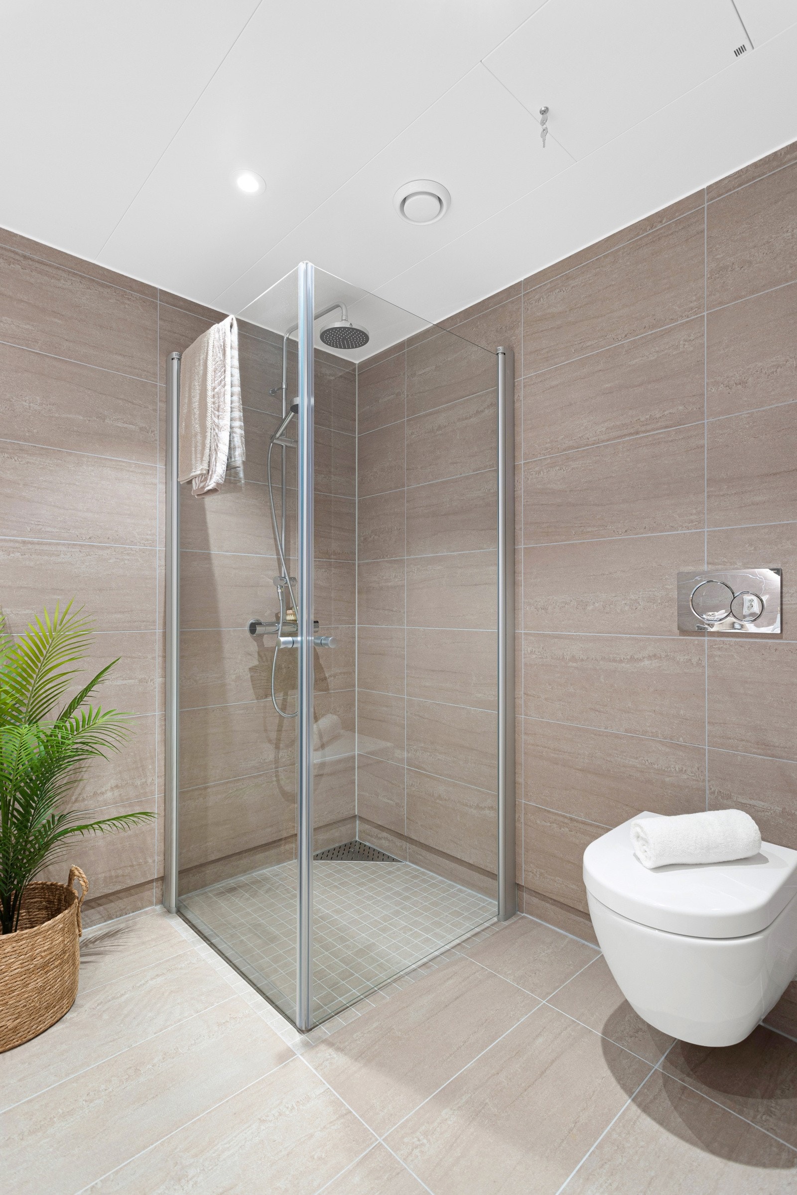 Baderommet består av dusjhjørne med glassvegger, servantskap med rundt lysspeil og vegghengt toalett. Galleribilde