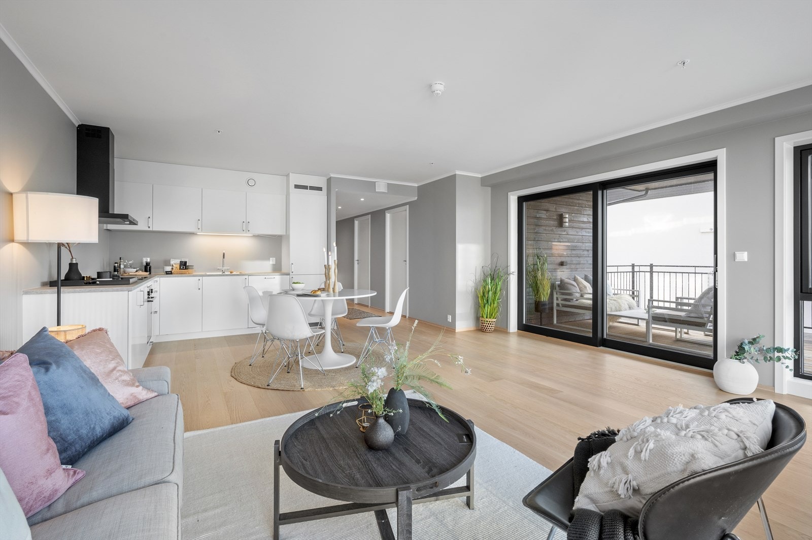 Leiligheten har store vindusflater og stor skyvedør ut til overbygget balkong Galleribilde