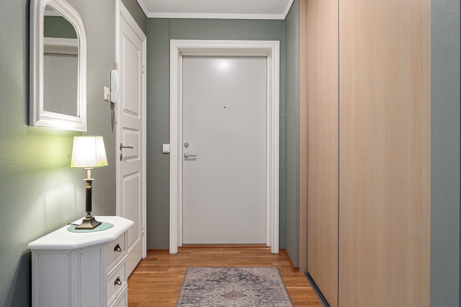 Entréen er lys og innbydende, med god plass til oppbevaring og en praktisk skyvedørsgarderobe. Den moderne løsningen gir både funksjonalitet og stil, og skaper et ryddig og organisert inngangsparti. Galleribilde