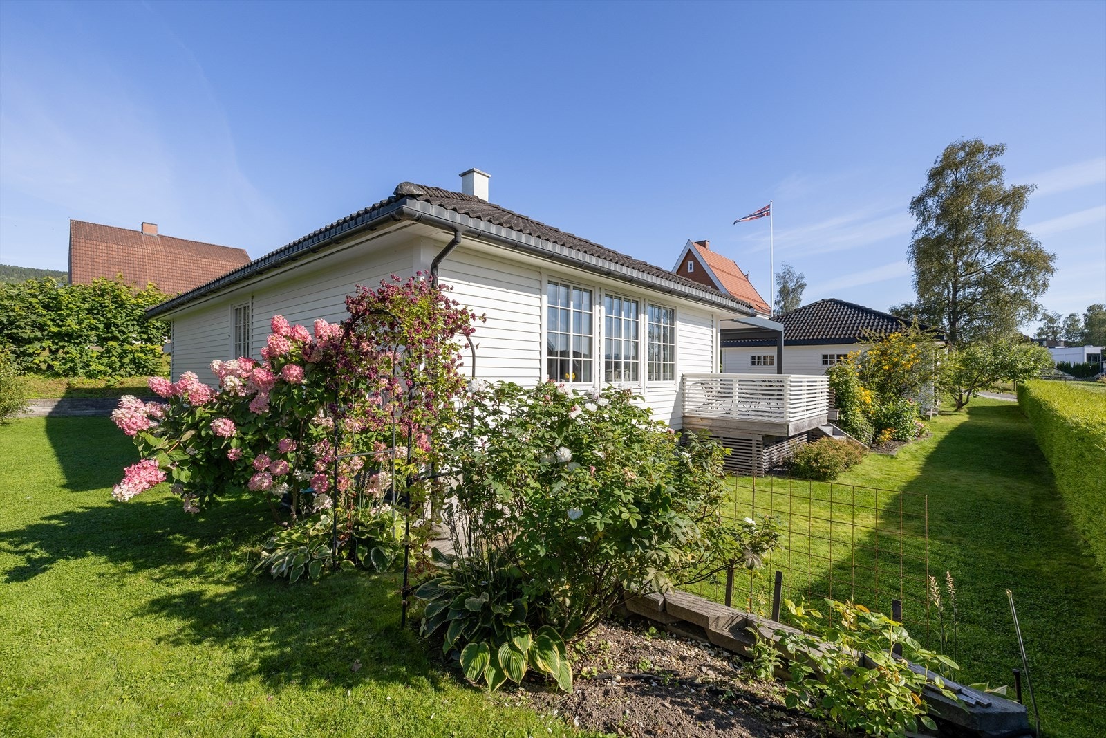 Idyllisk uteplass som rammer inn eiendommen på vakkert vis. Galleribilde