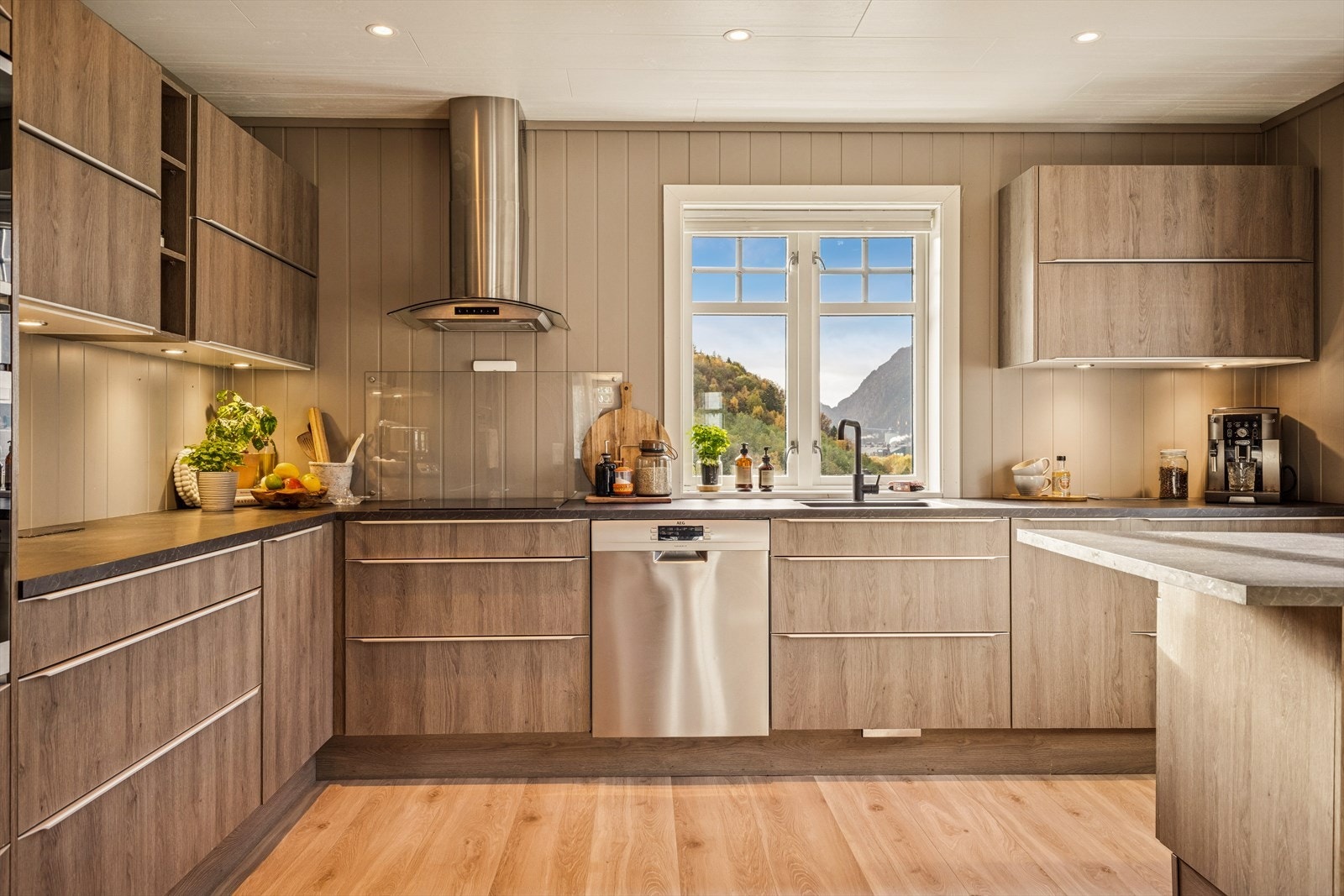 Kjøkkenet har et lyst og moderne uttrykk med en varm og naturlig atmosfære Galleribilde