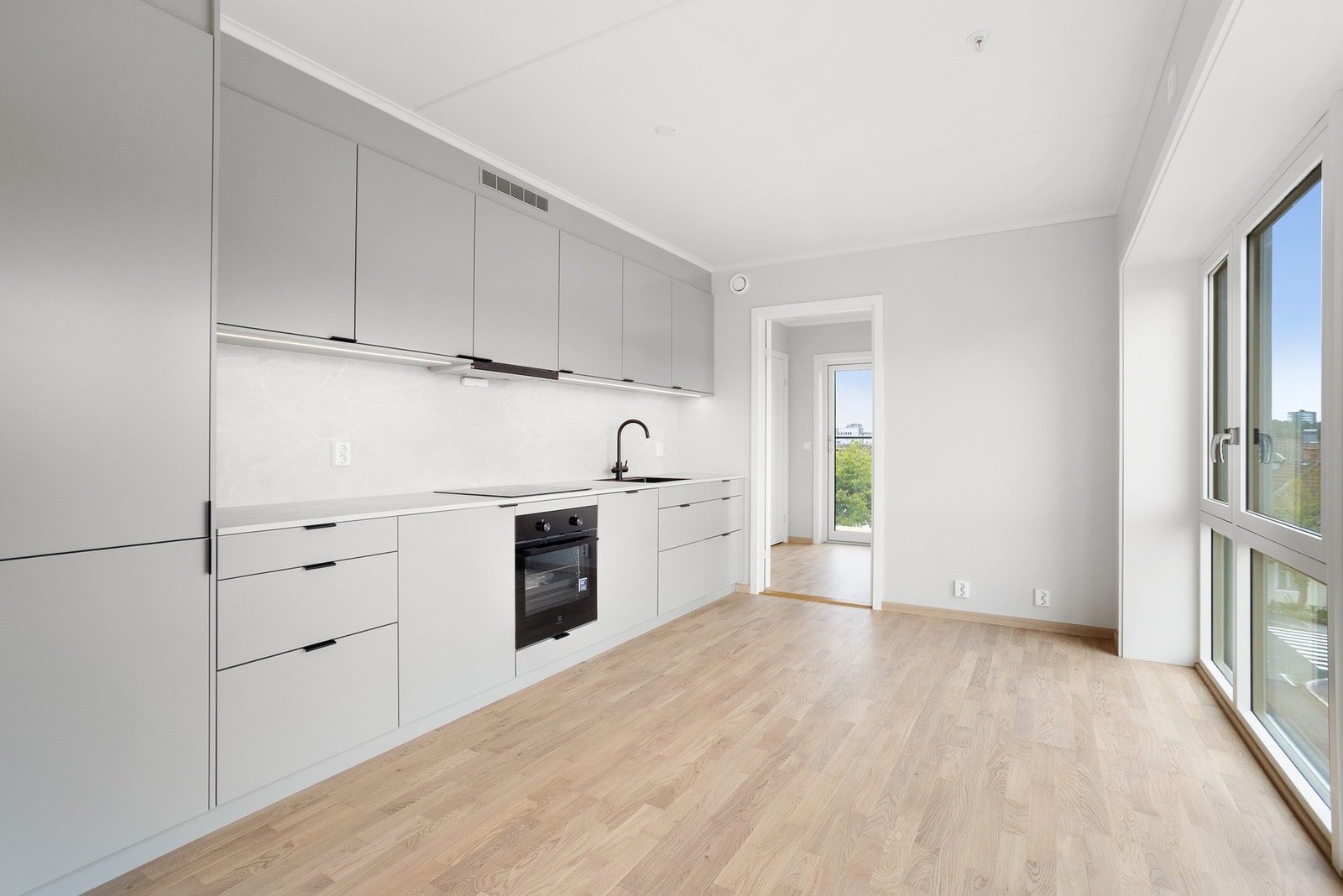 Oppgradert kjøkken fra Drømmekjøkken, med sorte detaljer, belysning under overskapene og veggplate lik benkeplate Galleribilde