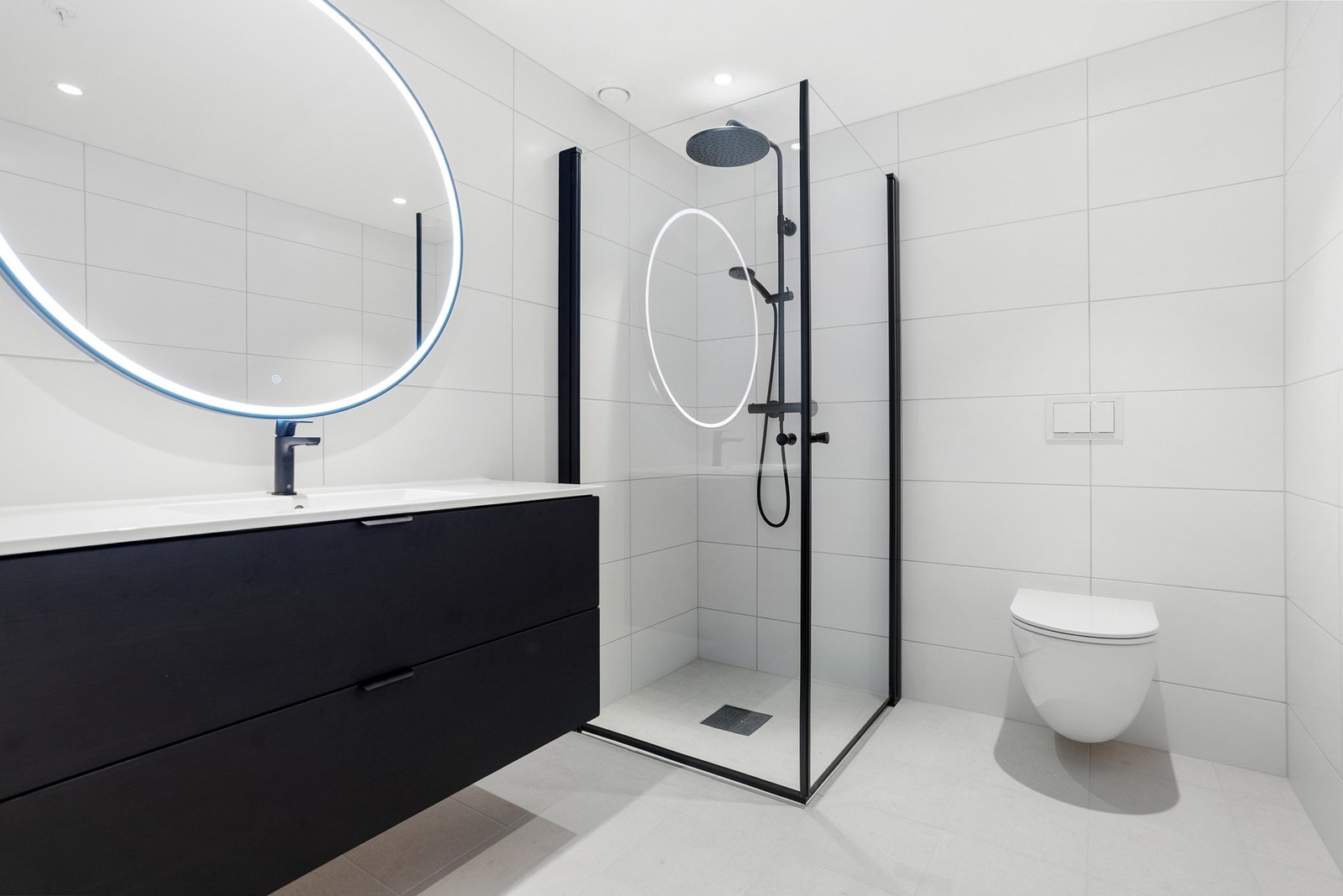 Delikat bad med flotte detaljer som speil med lys og dusjnisje med innfellbare glassdører. Galleribilde