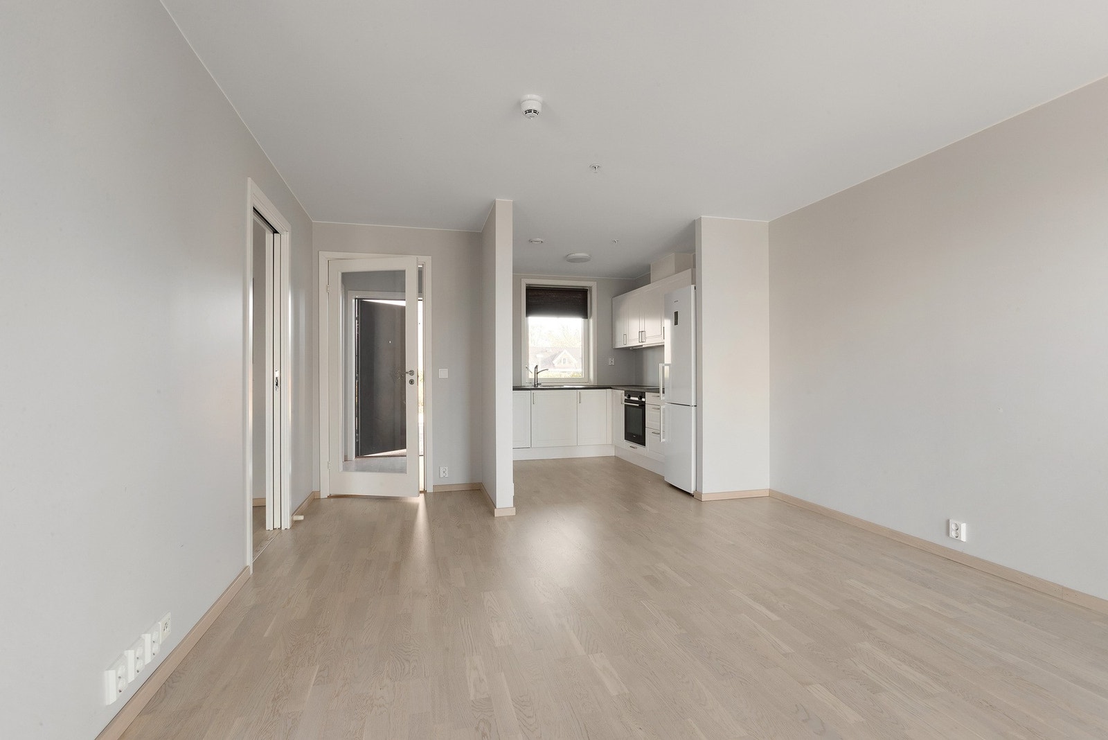 Åpen planløsning mellom stue og kjøkken gir en luftig romfølelse Galleribilde