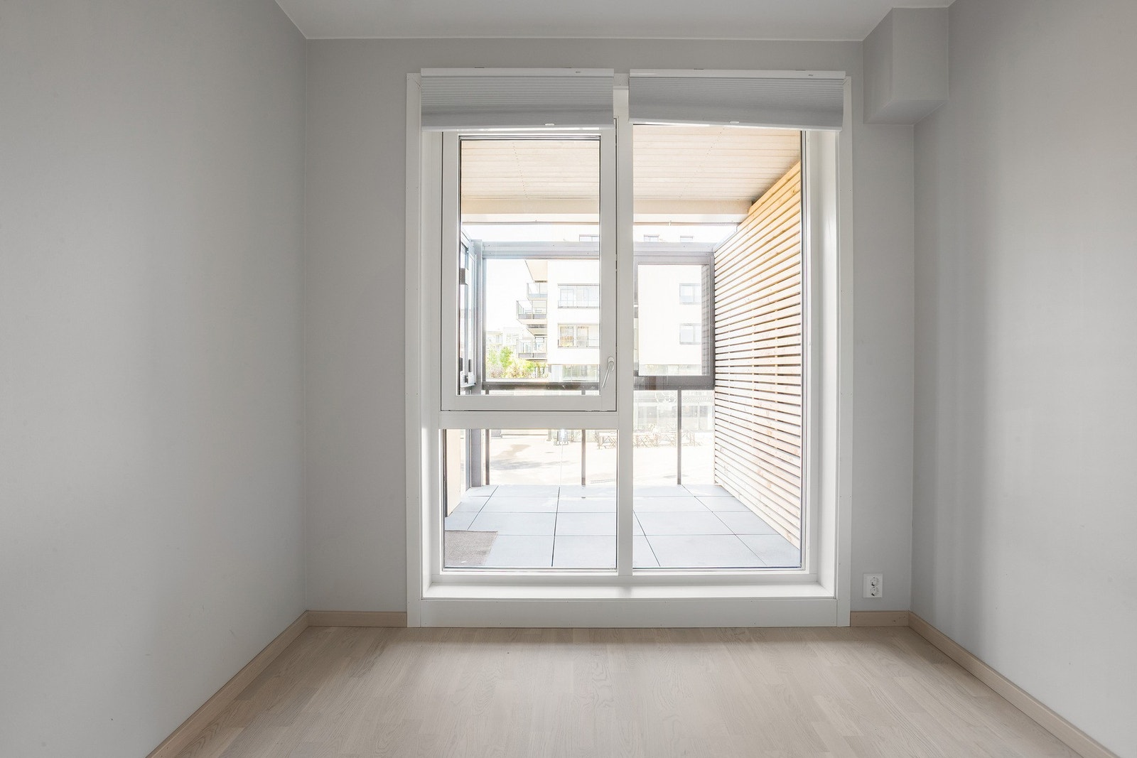 Lyst soverom med store vindusflater og plass til seng og garderobeskap Galleribilde