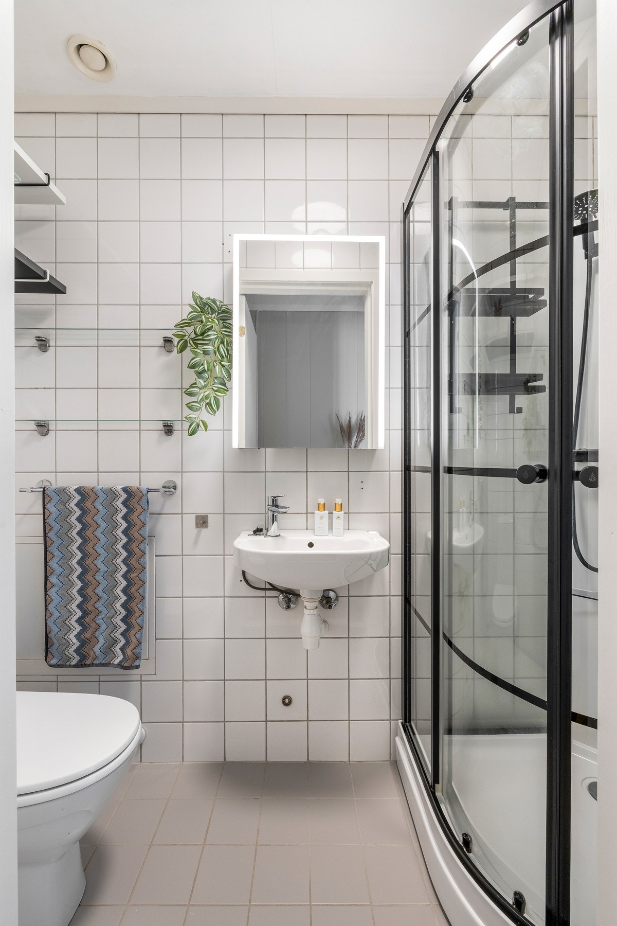 Leiligheten har et velholdt og pent bad fra 2005 med hvite fliser på veggene og lysegrå fliser på gulv med gulvvarme. Galleribilde