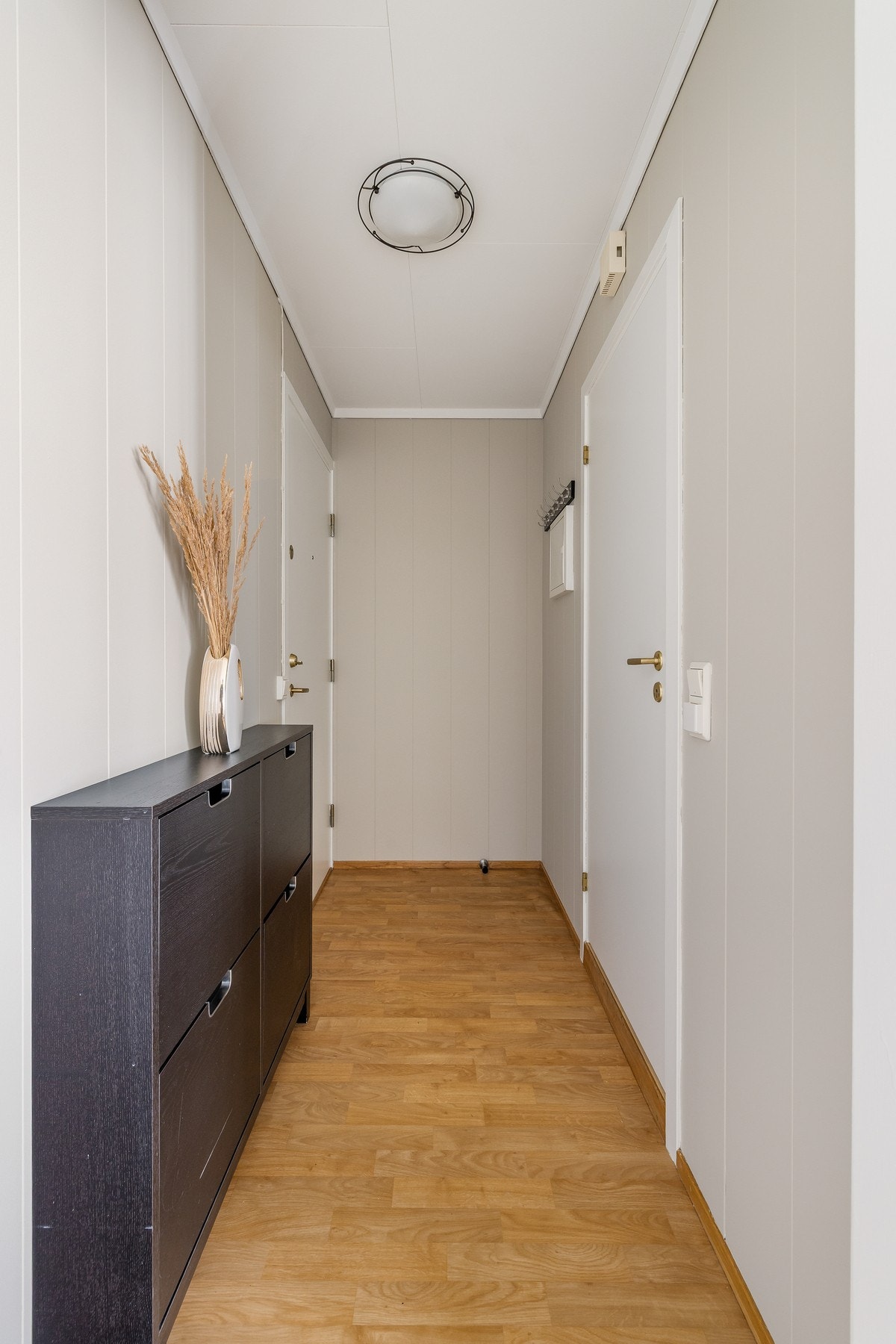 Vel inne blir vi ønsket velkommen i en pen entré med lysmalte vegger og belegg i parkettimitasjon på gulvet. Galleribilde