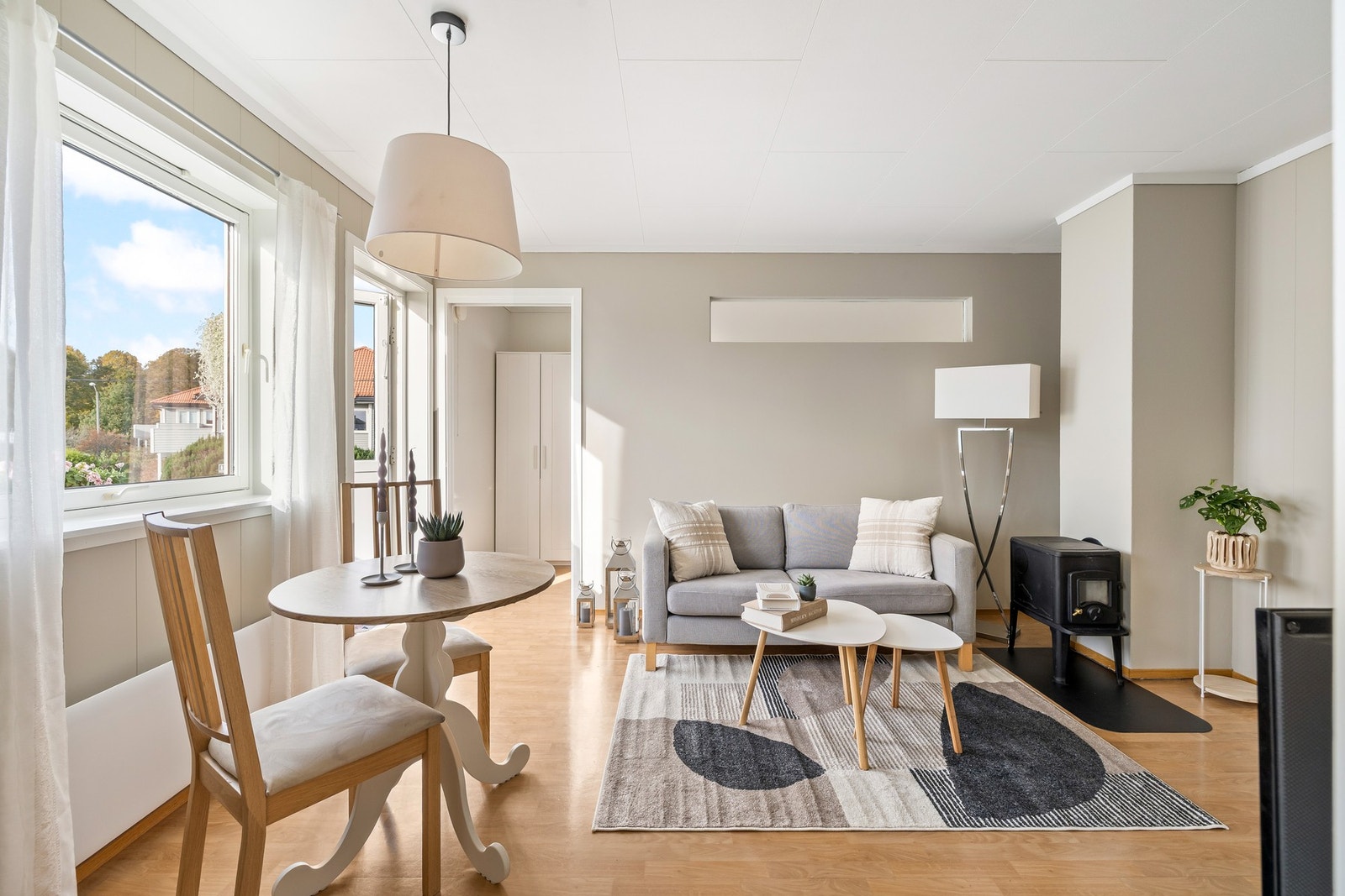 Stuen har belegg i parkettimitasjon på gulvet, hvitmalte vegger og en god peisovn i støpejern i det ene hjørnet. Galleribilde