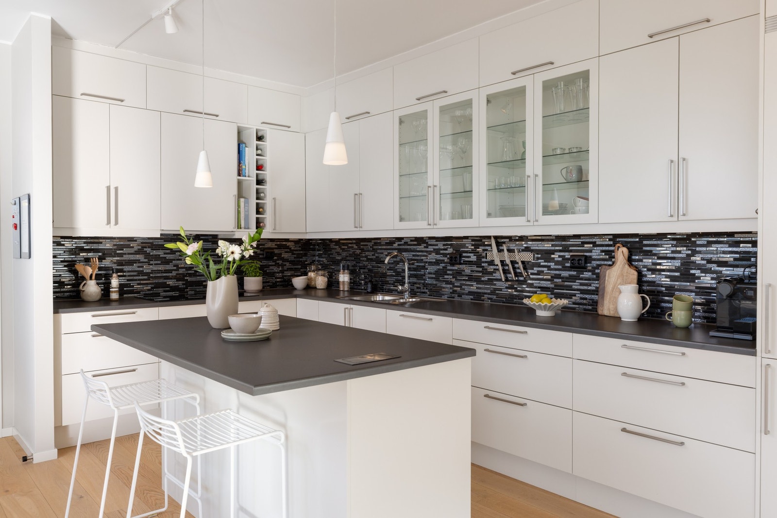 En praktisk kjøkkenøy med strømuttak gir ekstra benke- og skapplass, samt plass til barstoler for uformelle måltider. Galleribilde