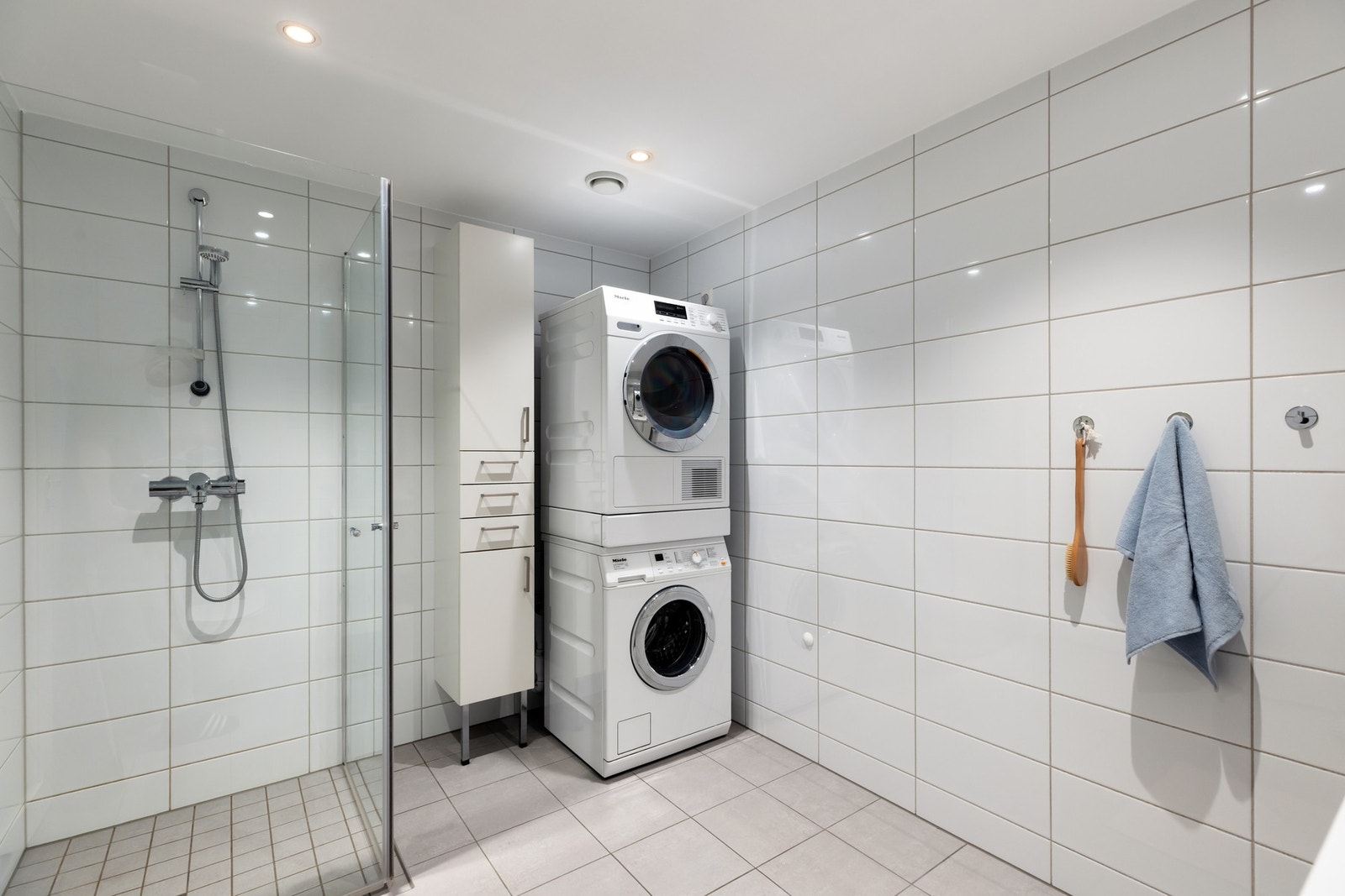 Badet har opplegg for vaskemaskin og plass til tørketrommel - funksjonelt og moderne. Galleribilde