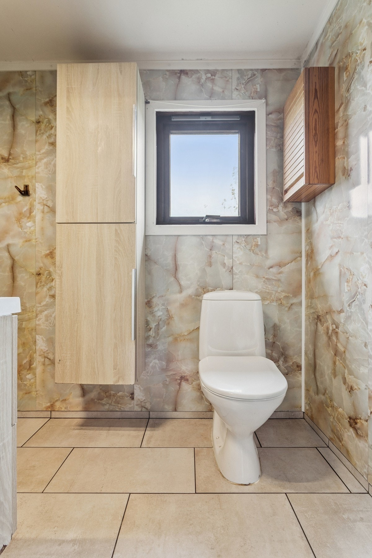 Badet er innredet med klosett, dusj, servant med speil over og skap. Galleribilde