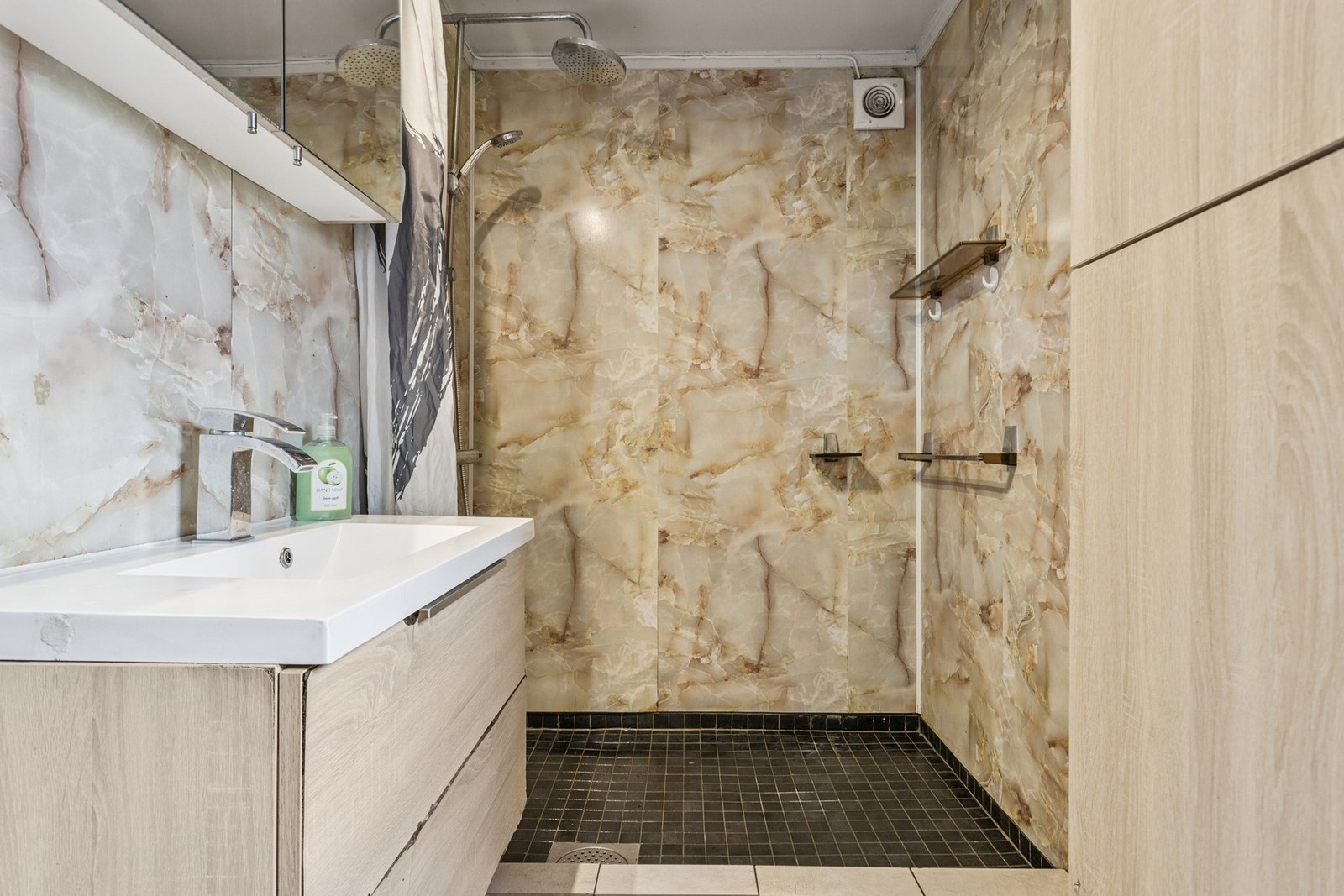 Badet ligger rett ved gange, flislagt gulv og baderomsplater. Galleribilde