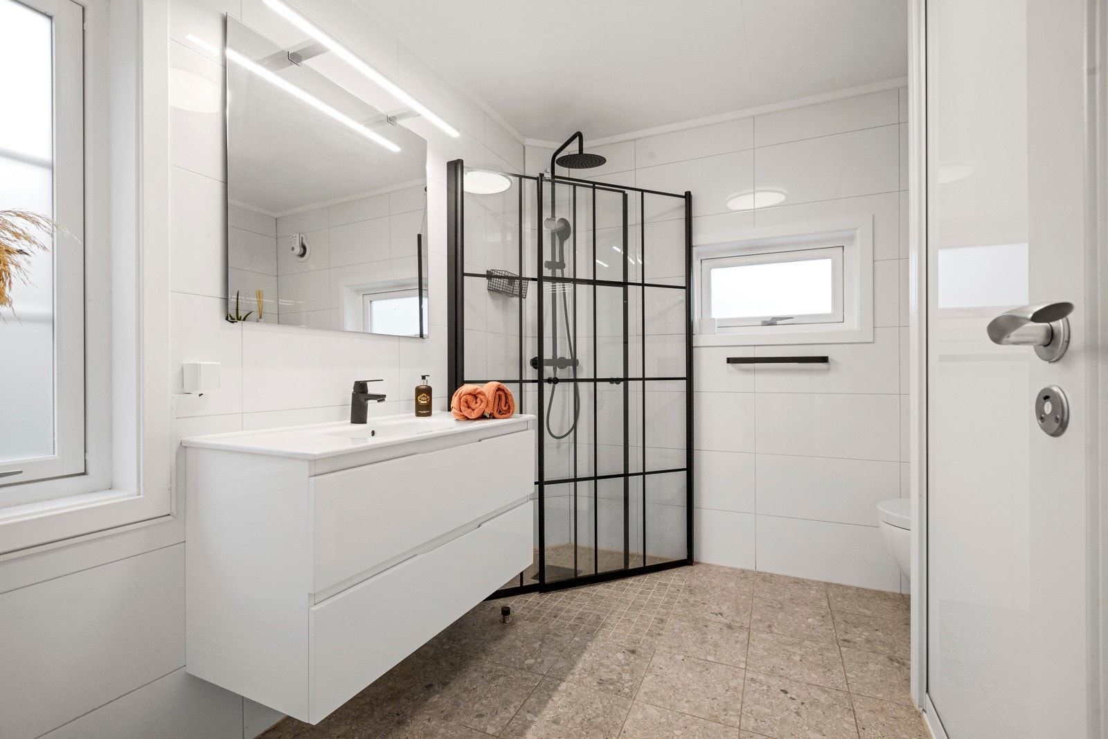 Vi har et bad i 1. etasje med fliser på vegg og gulv- i tillegg til garderobe Galleribilde