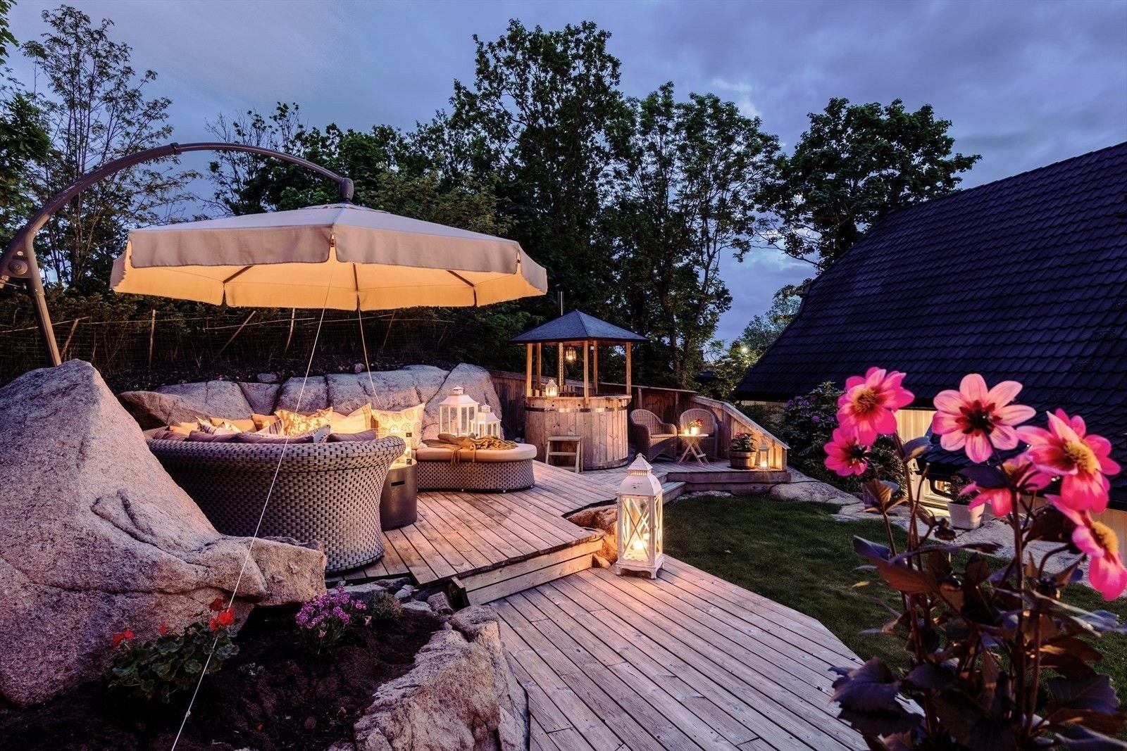 Tomtens høyeste og mest solrike del byr på flere soner: badestamp, spiseplass, stor buet salong og gasspeis. Her skapes magiske kvelder med familie og venner. Galleribilde