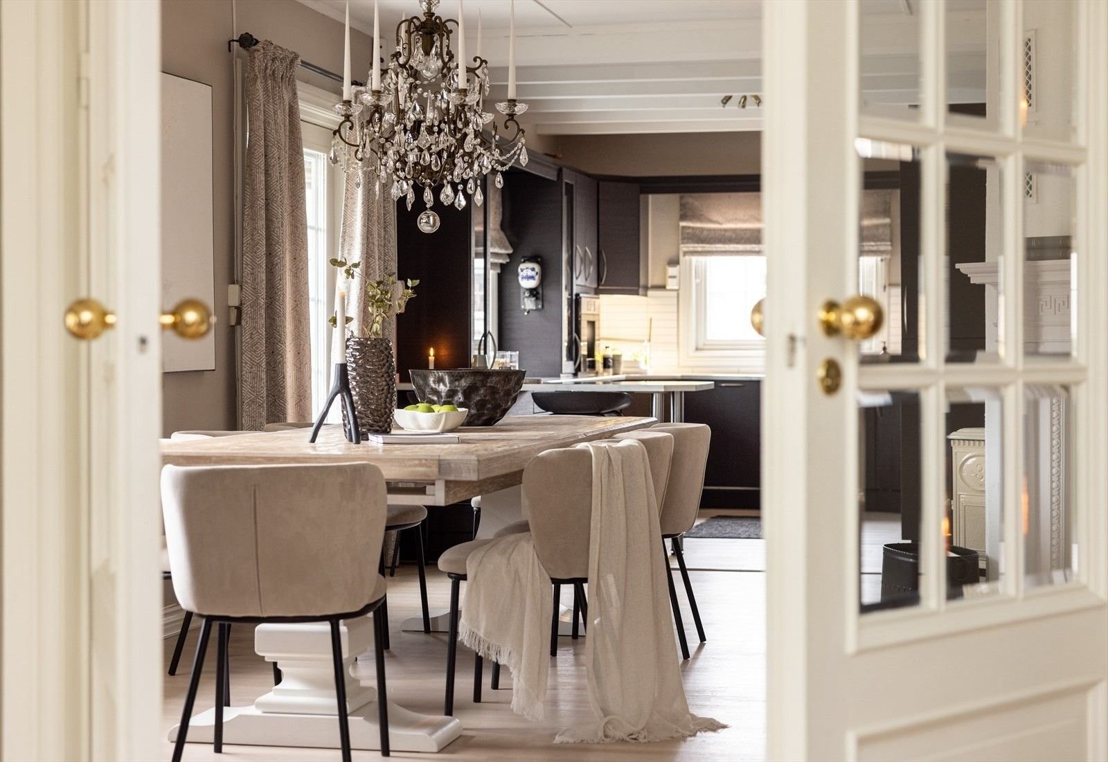 Spisestue mot kjøkken og kjøkkenstue. Dobbeltdører med massive messinghåndtak tilfører eksklusivitet. Galleribilde