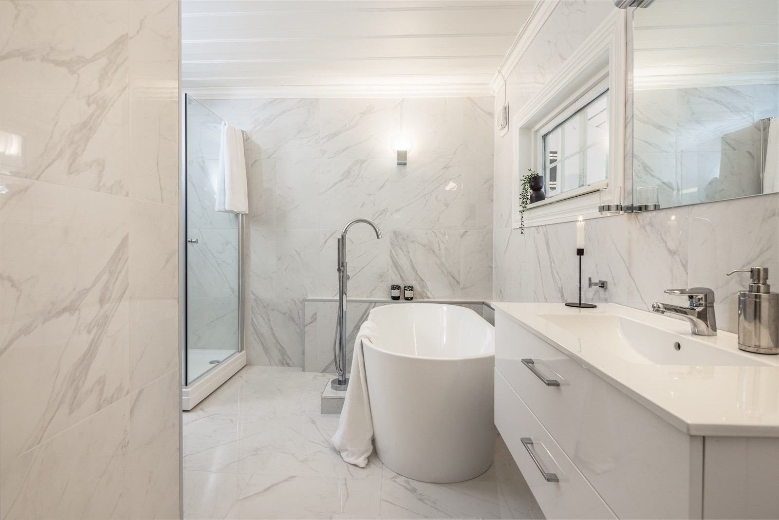 Stor dusjsone (100x100 cm), toalett og badekar med elegant gulvmontert armatur og hånddusj. Galleribilde