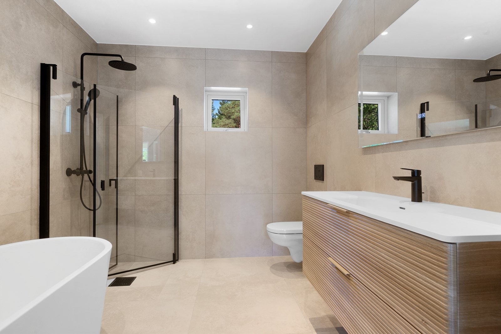 Begge bad har moderne keramiske fliser, gulvvarme og tidløs innredning. Galleribilde