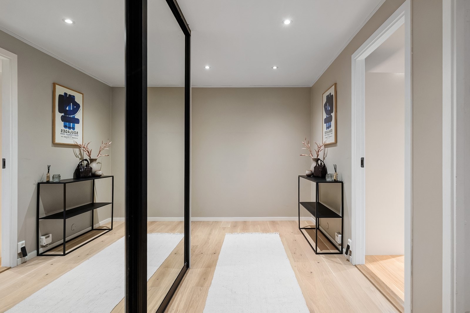 Stor og innbydende entré som deler opp boligens øvrige rom. Galleribilde